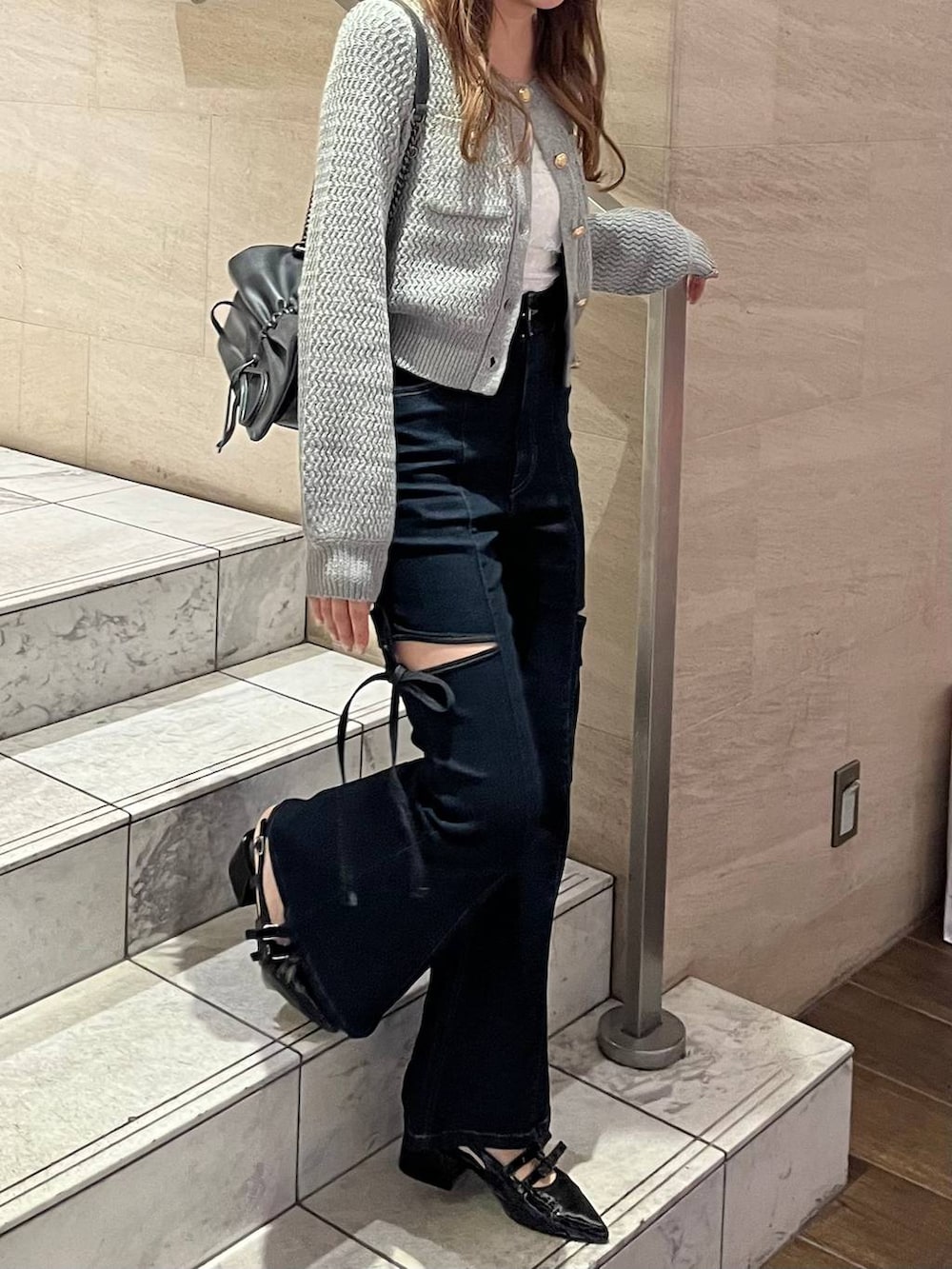 グレー系のショルダーバッグ、ブラック系のパンプス、ブルー系のデニムパンツを着用したレディースの春コーディネートの8枚目の写真