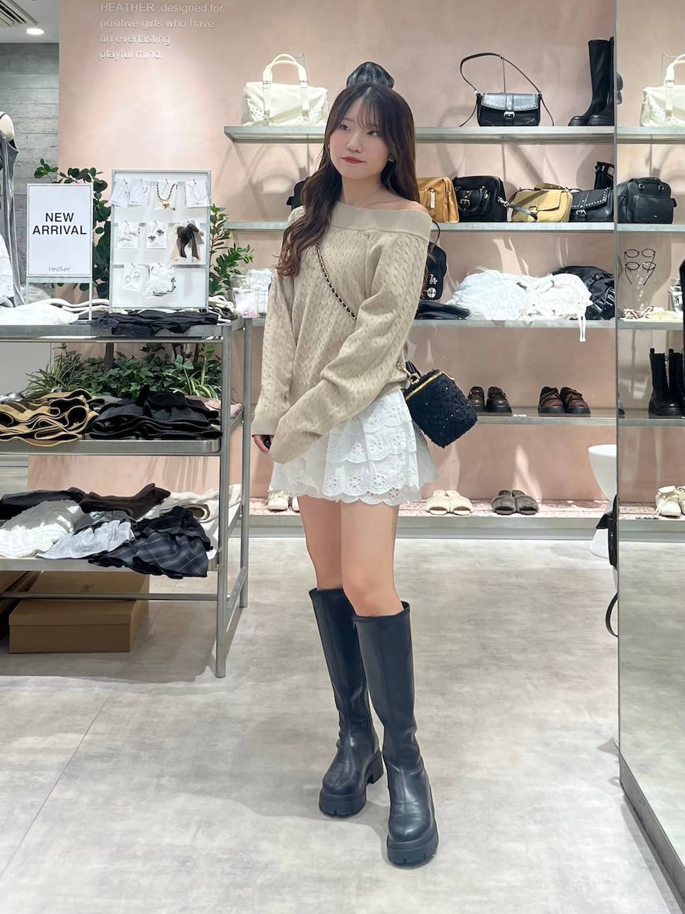 ブラック系のブーツ、ホワイト系のその他パンツ、ベージュ系のニット/セーターを着用したレディースの秋コーディネートの2枚目の写真