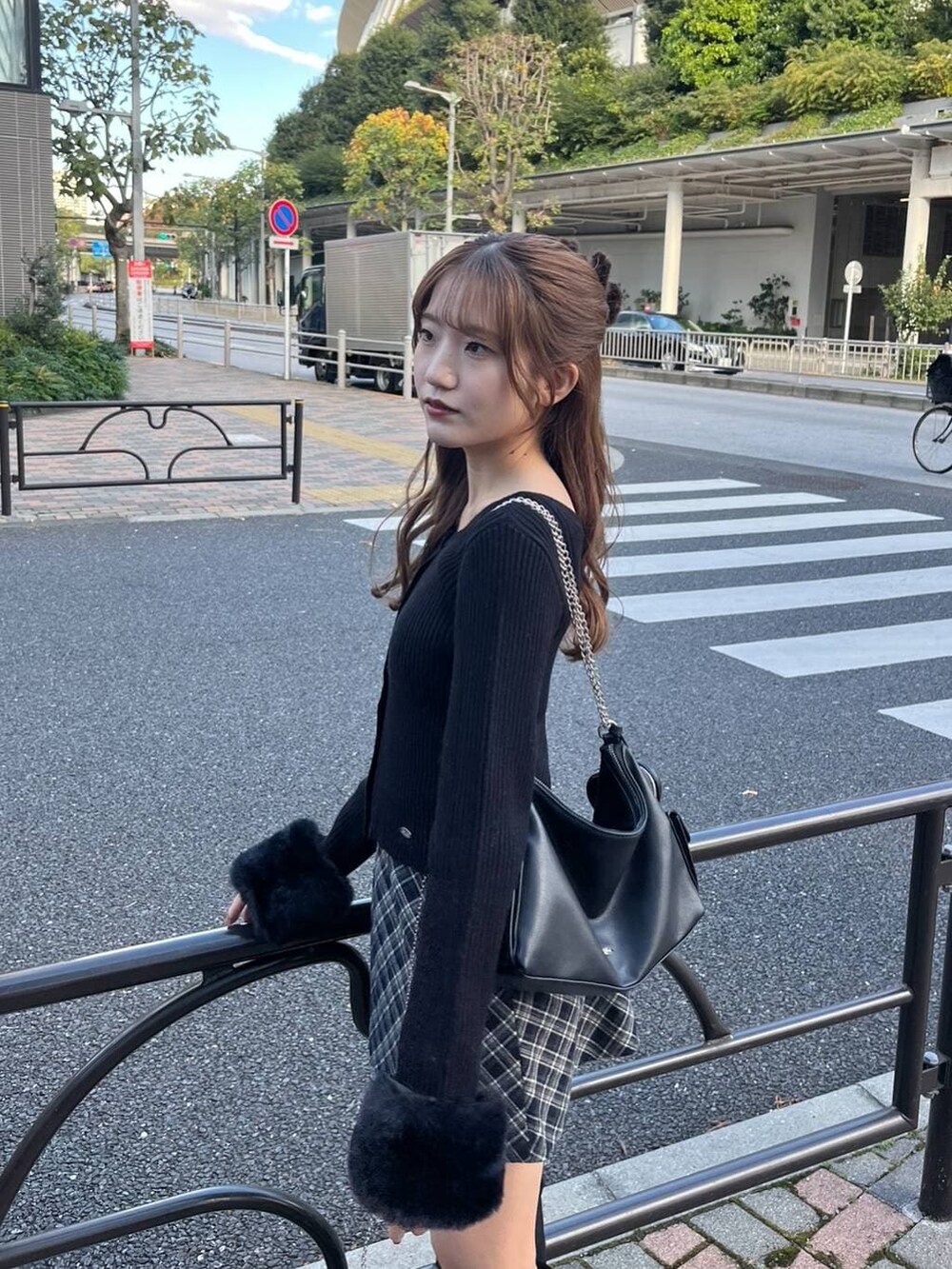 ブラック系のブーツ、ブルー系のスカート、ブラック系のショルダーバッグを着用したレディースの冬コーディネートの4枚目の写真