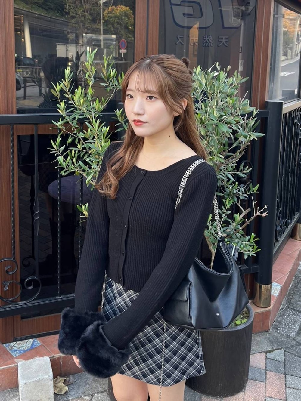 ブラック系のブーツ、ブルー系のスカート、ブラック系のショルダーバッグを着用したレディースの冬コーディネートの2枚目の写真