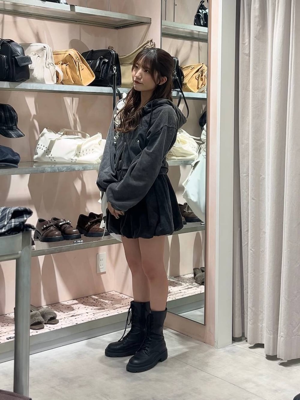 ホワイト系のキャミソール、ブラック系のスカート、ブラック系のパーカーを着用したレディースの秋コーディネートの4枚目の写真