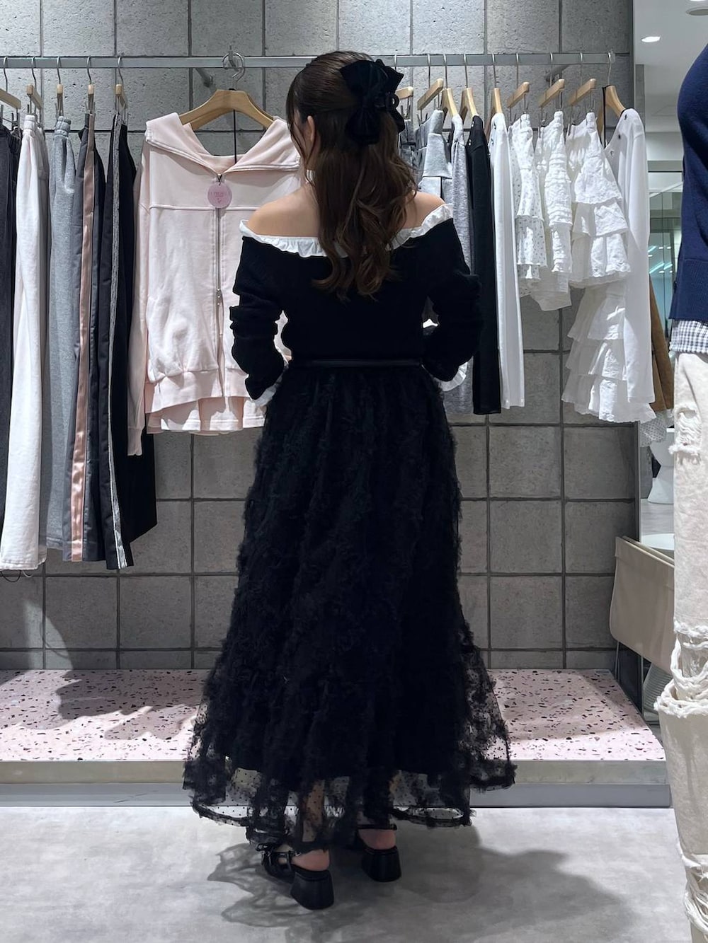 グレー系のショルダーバッグ、ブラック系のパンプス、ブラック系のスカートを着用したレディースの春コーディネートの3枚目の写真