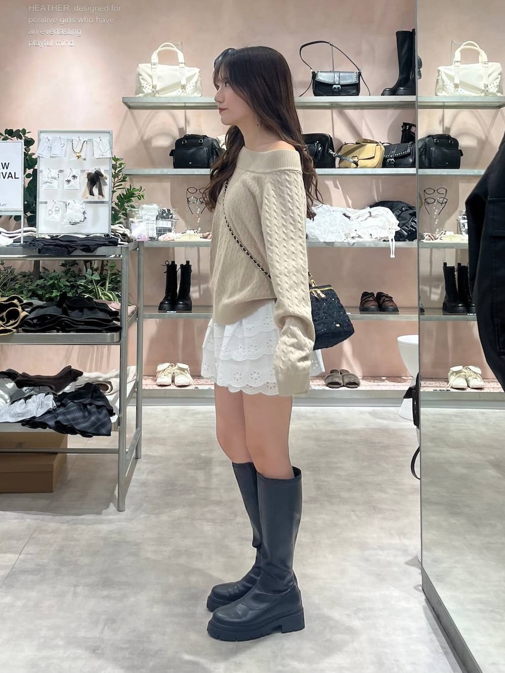 ブラック系のブーツ、ホワイト系のその他パンツ、ベージュ系のニット/セーターを着用したレディースの秋コーディネートの3枚目の写真