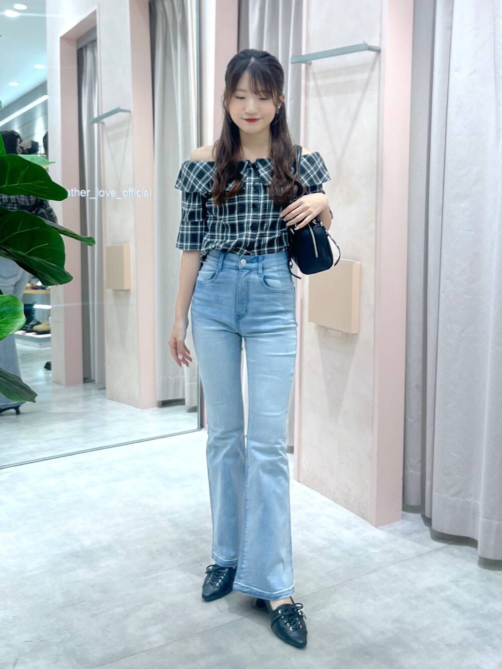 ブラック系のサンダル、ブラック系のシャツ/ブラウス、ブルー系のデニムパンツを着用したレディースの夏コーディネートの2枚目の写真