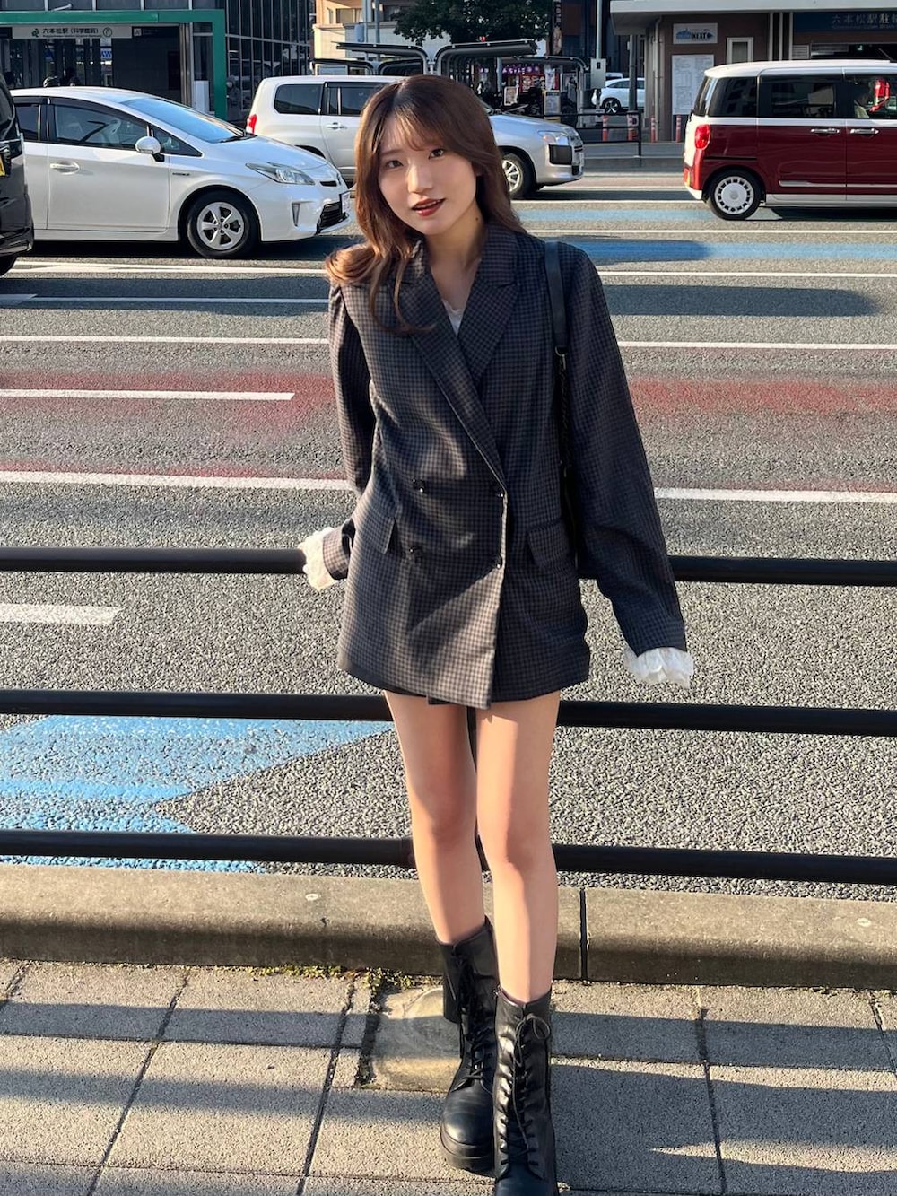 グレー系のショルダーバッグ、ホワイト系のキャミソール、グレー系のテーラードジャケットを着用したレディースの冬コーディネートの4枚目の写真