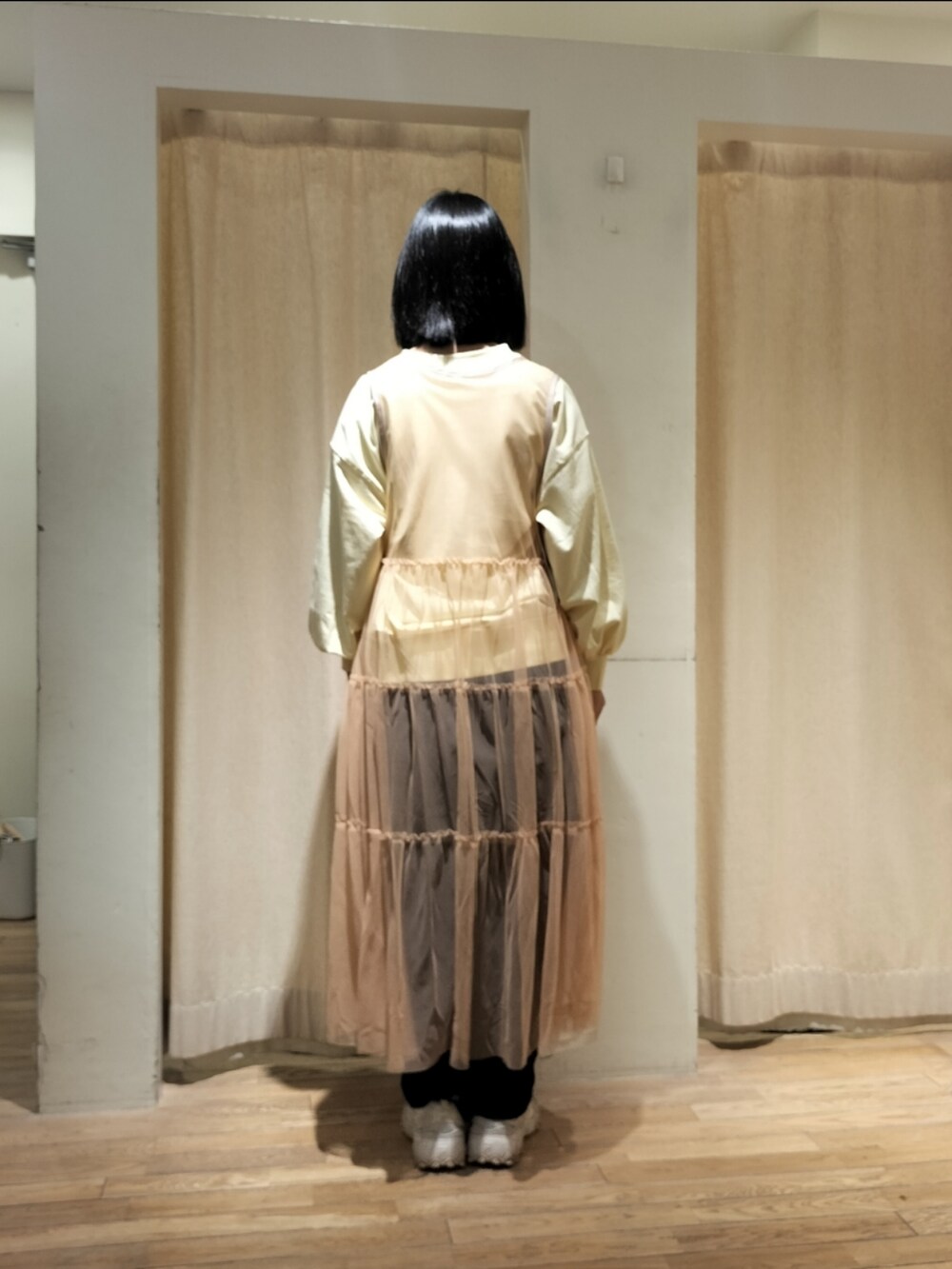 ブルー系のデニムパンツ、オレンジ系のワンピースを着用したレディースの春コーディネートの3枚目の写真