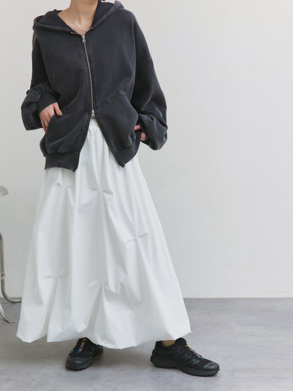 ホワイト系のスカート、グレー系のパーカーを着用したレディースの冬コーディネートの2枚目の写真