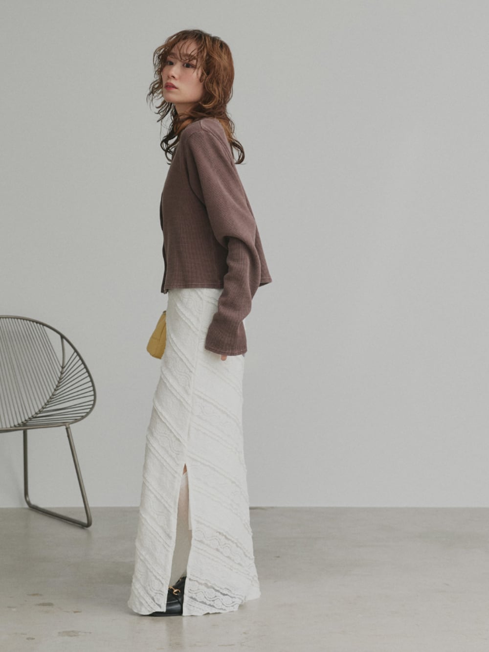 ブラウン系のカーディガン/ボレロ、ホワイト系のスカートを着用したレディースの冬コーディネートの3枚目の写真