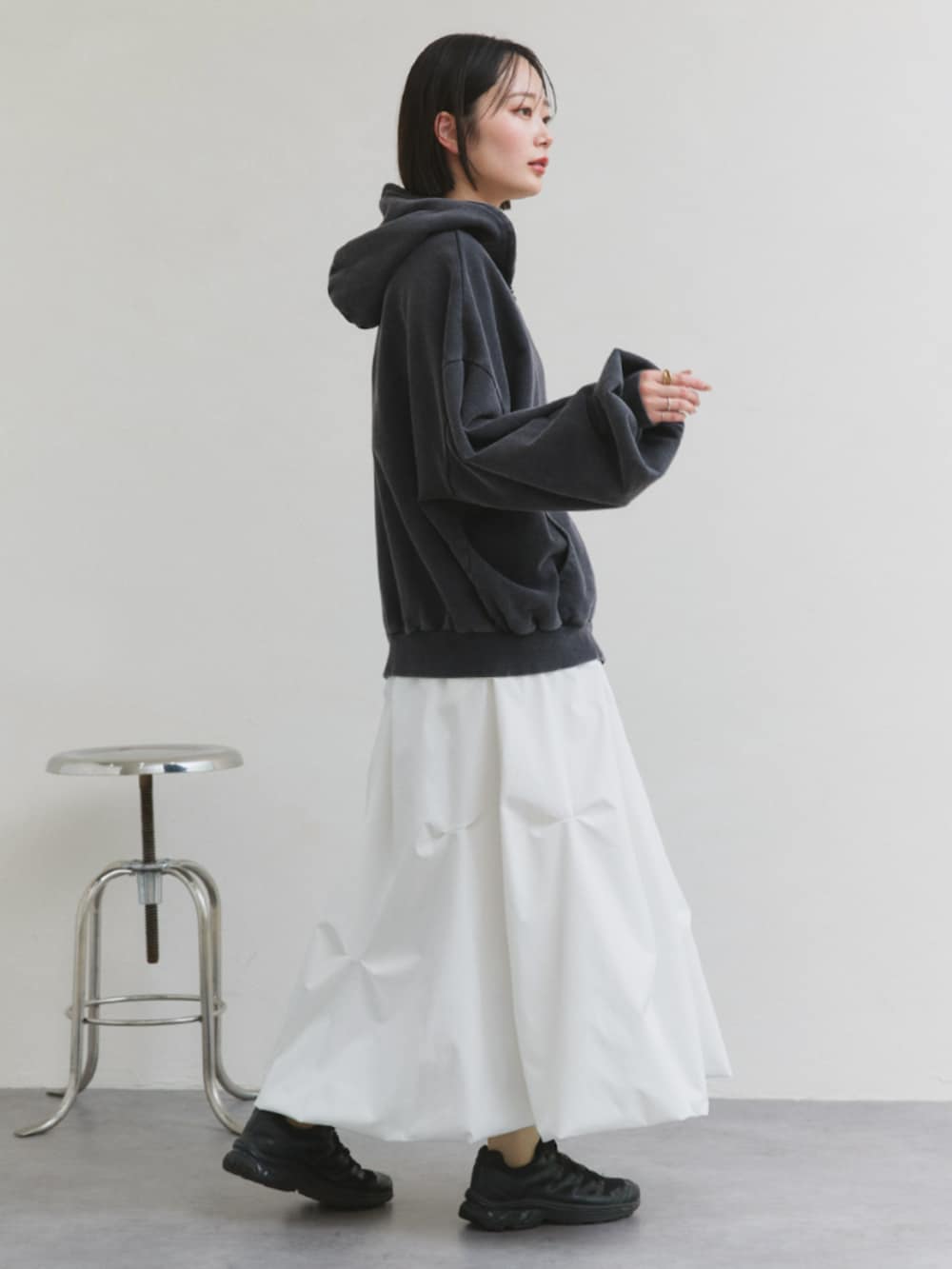 ホワイト系のスカート、グレー系のパーカーを着用したレディースの冬コーディネートの3枚目の写真