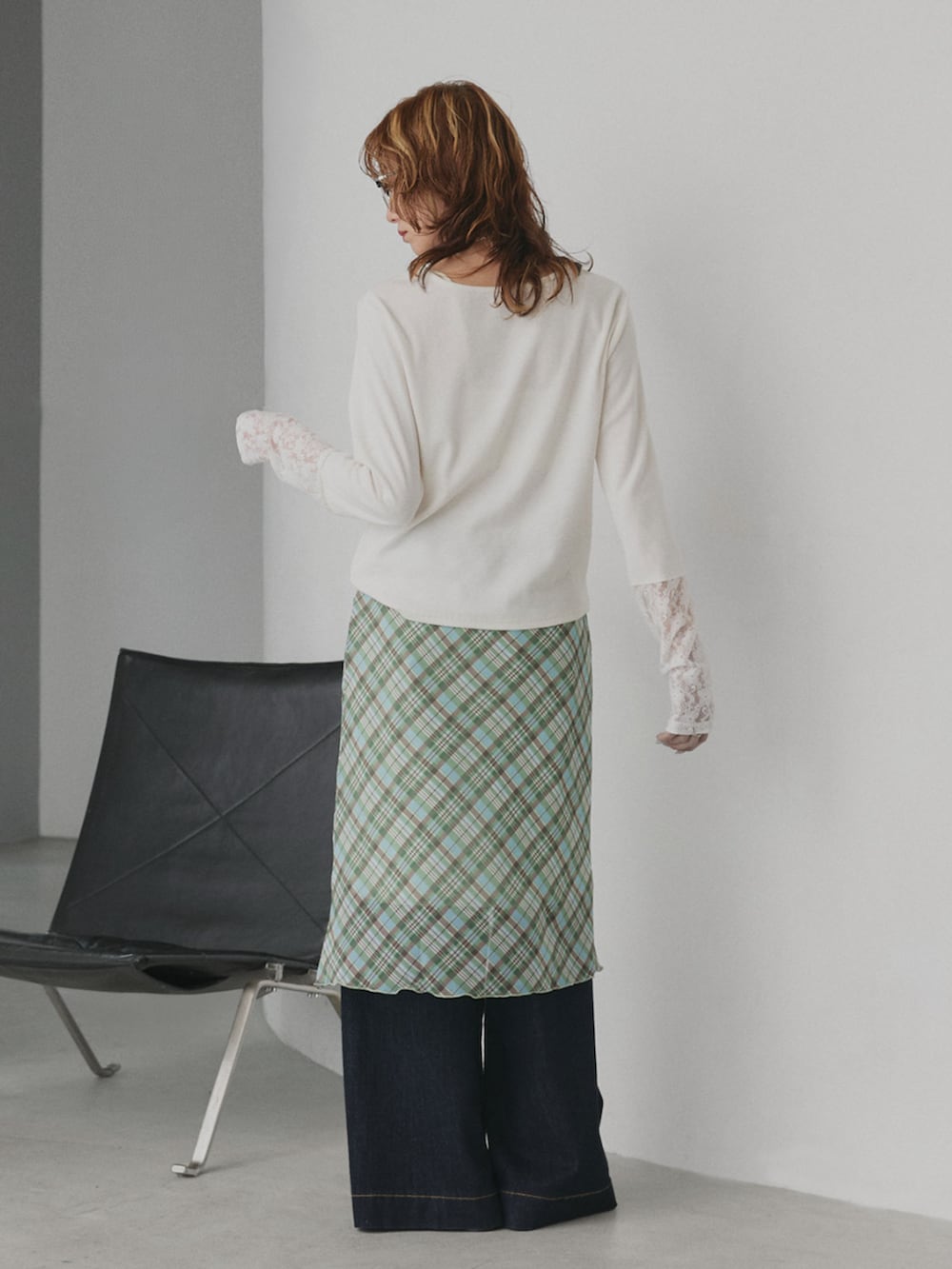 ブルー系のデニムパンツ、ホワイト系のTシャツ/カットソー、グリーン系のスカートを着用したレディースの春コーディネートの2枚目の写真