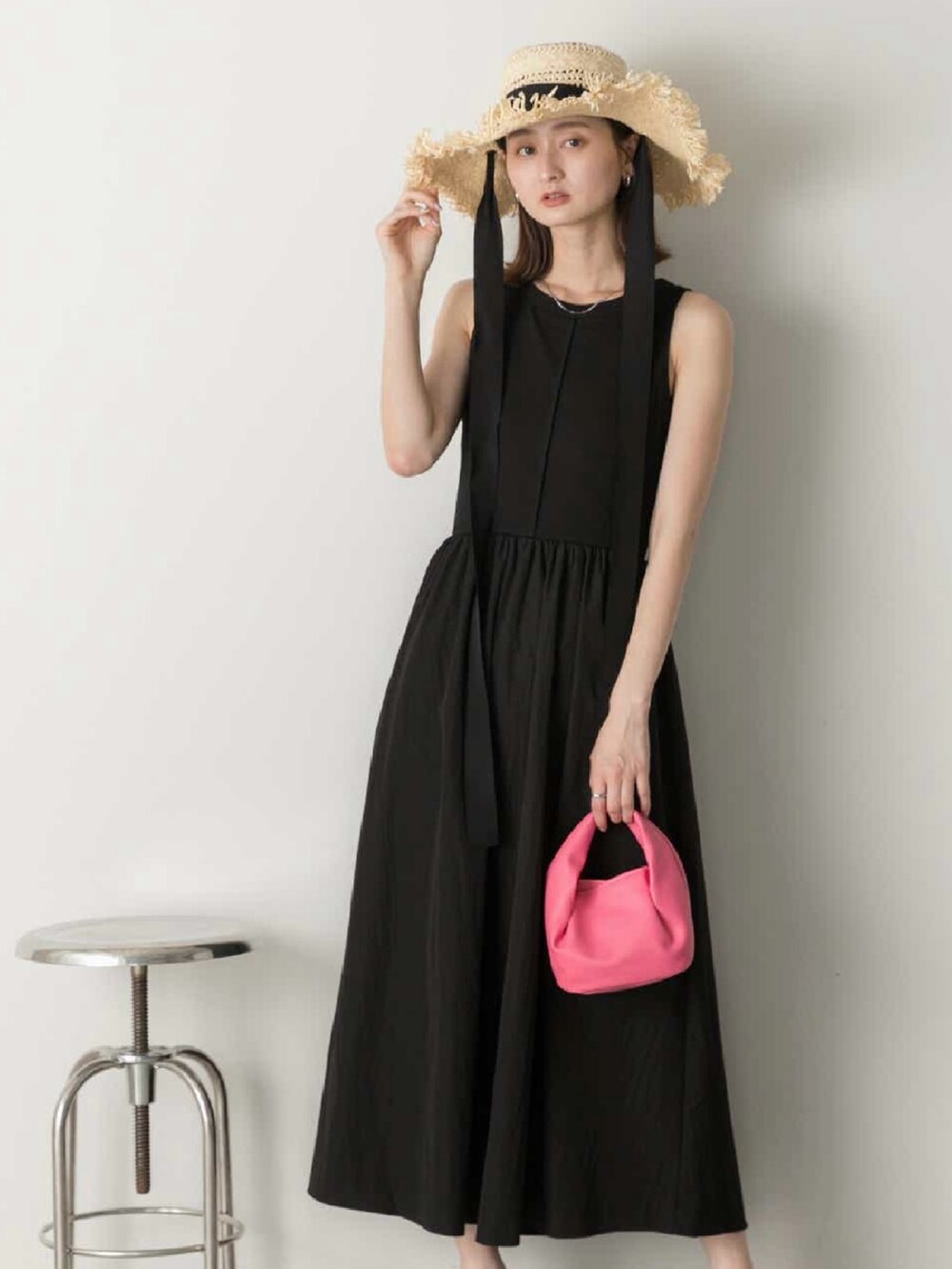 グレー系のキャミソール、ピンク系のショルダーバッグ、ブラック系のスカートを着用したレディースの夏コーディネートの3枚目の写真