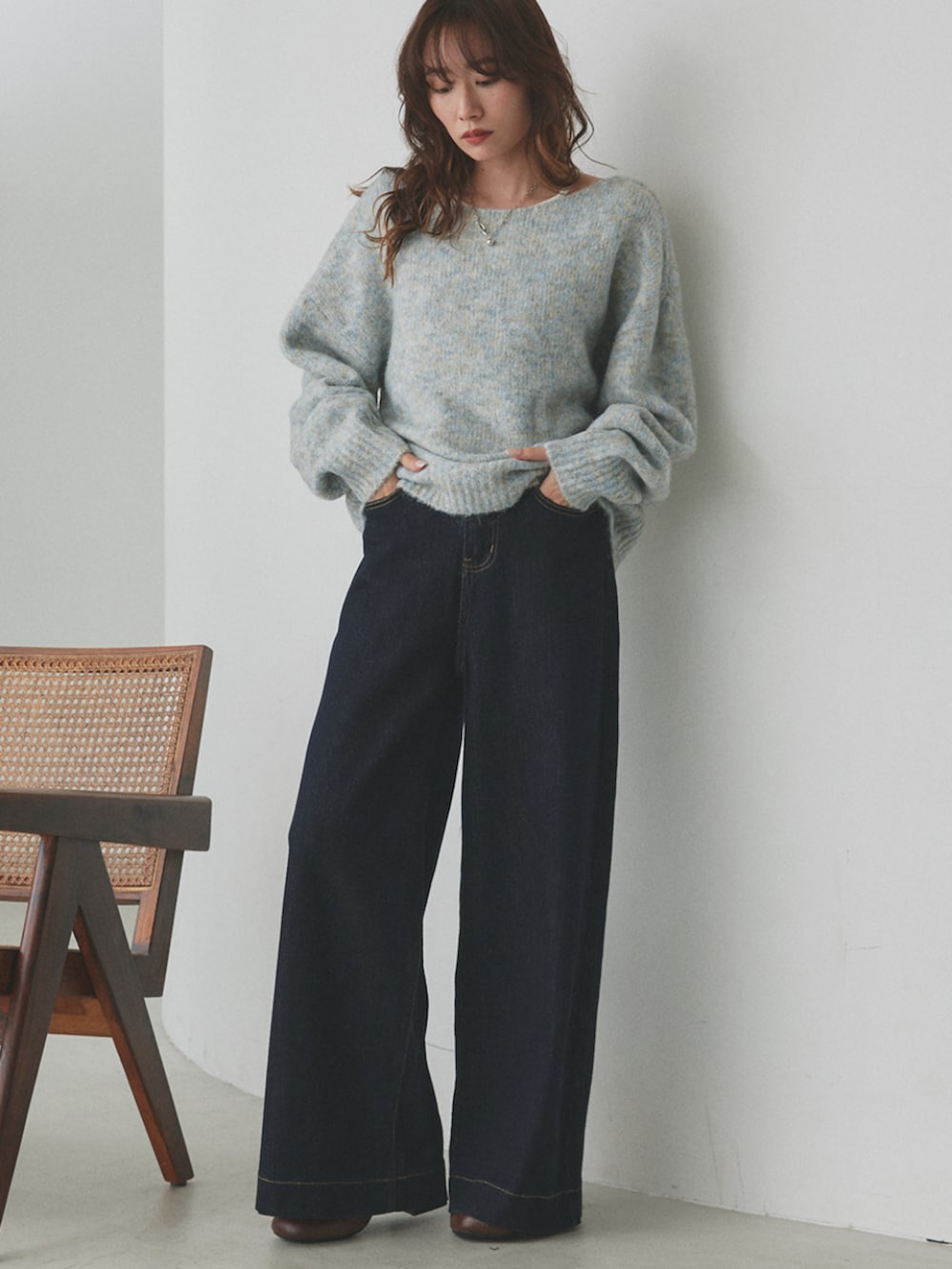 ブルー系のデニムパンツ、グレー系のニット/セーターを着用したレディースの秋コーディネートの2枚目の写真