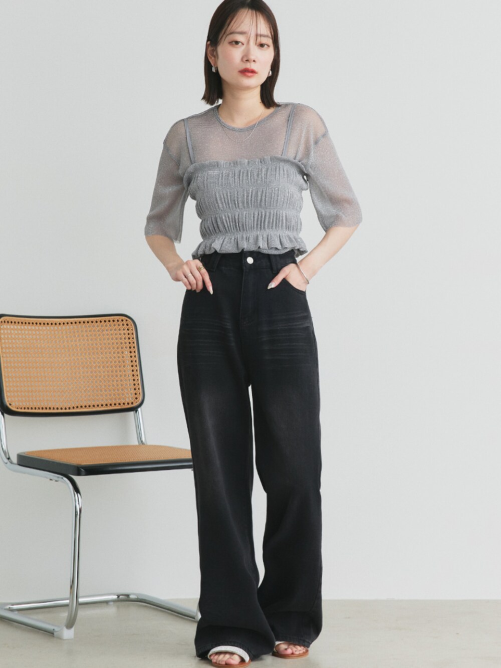 ブラック系のデニムパンツ、シルバー系のサンダル、グレー系のTシャツ/カットソーを着用したレディースの夏コーディネートの2枚目の写真