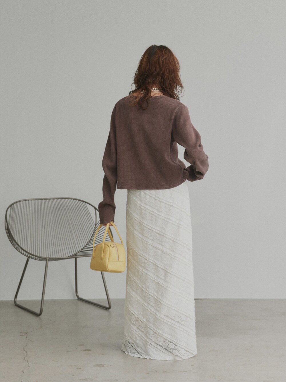 ブラウン系のカーディガン/ボレロ、ホワイト系のスカートを着用したレディースの冬コーディネートの2枚目の写真