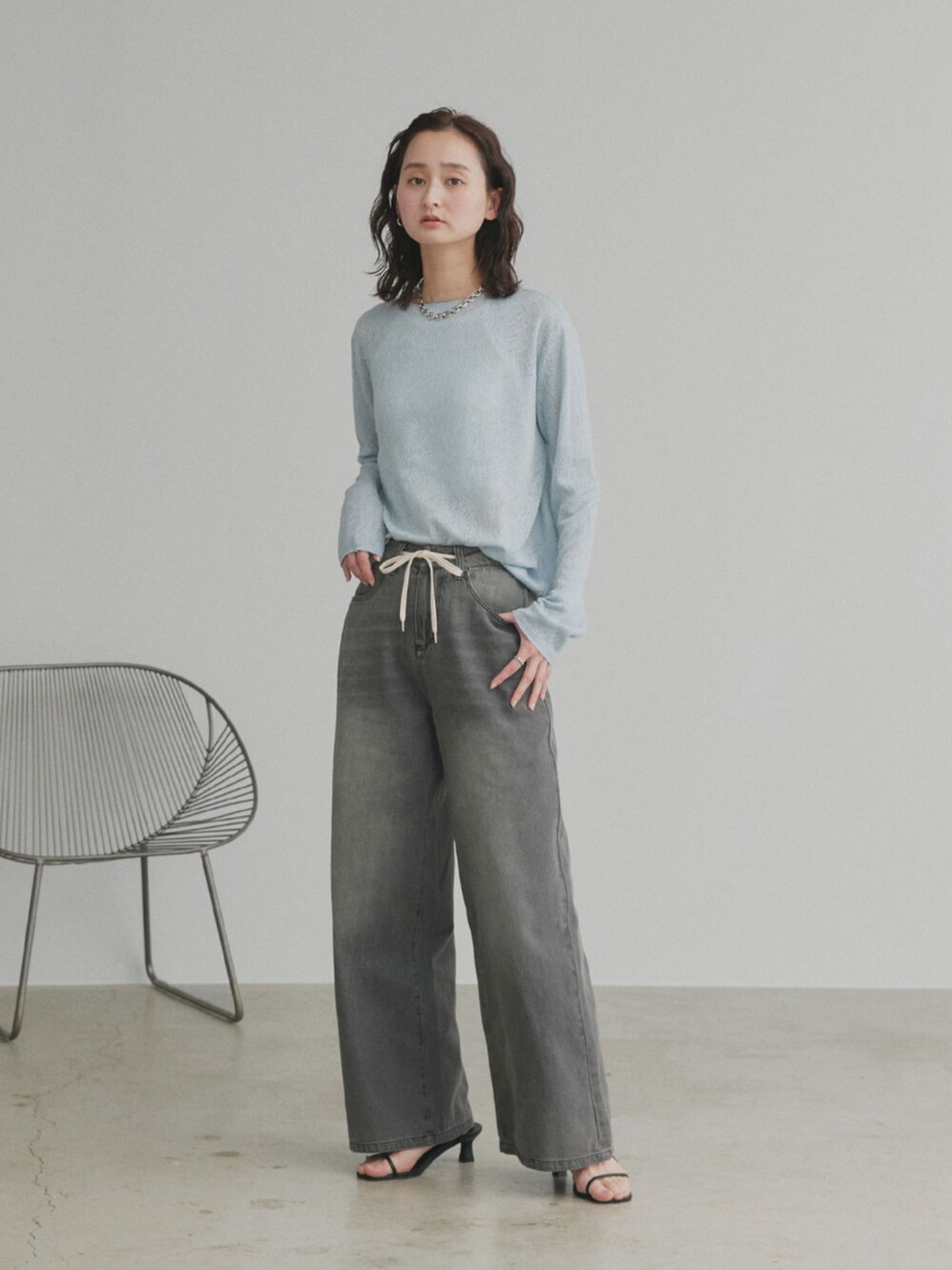 ブラック系のデニムパンツ、ブルー系のニット/セーターを着用したレディースの冬コーディネートの2枚目の写真