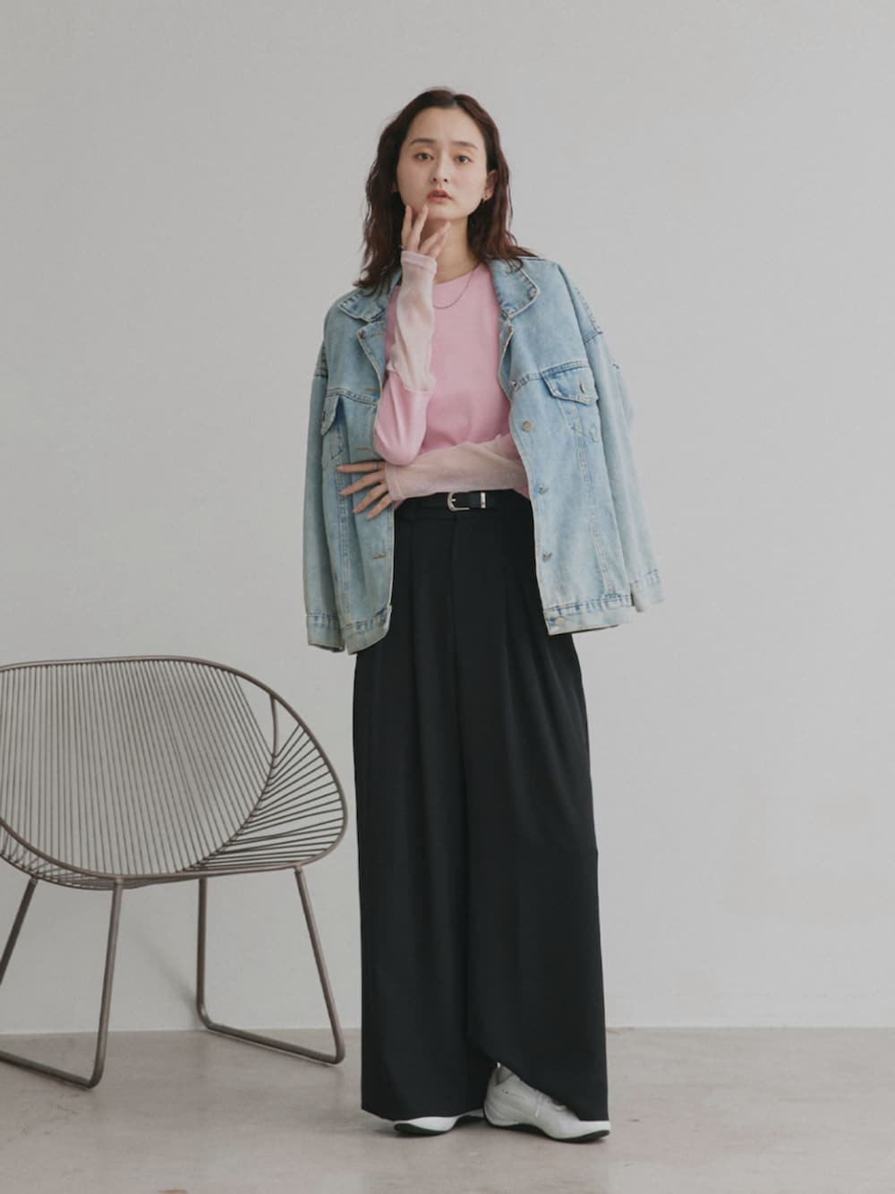 ブラック系のスラックス、ピンク系のTシャツ/カットソー、ブルー系のデニムジャケットを着用したレディースの冬コーディネートの2枚目の写真