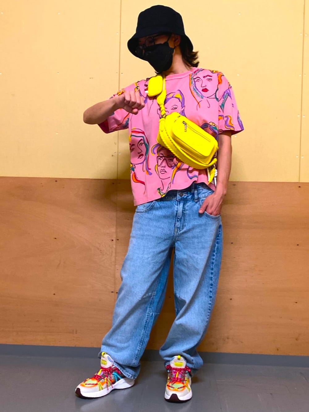 ブルー系のデニムパンツ、イエロー系のボディバッグ/ウエストポーチ、グリーン系の財布を着用したレディースの春コーディネートの3枚目の写真