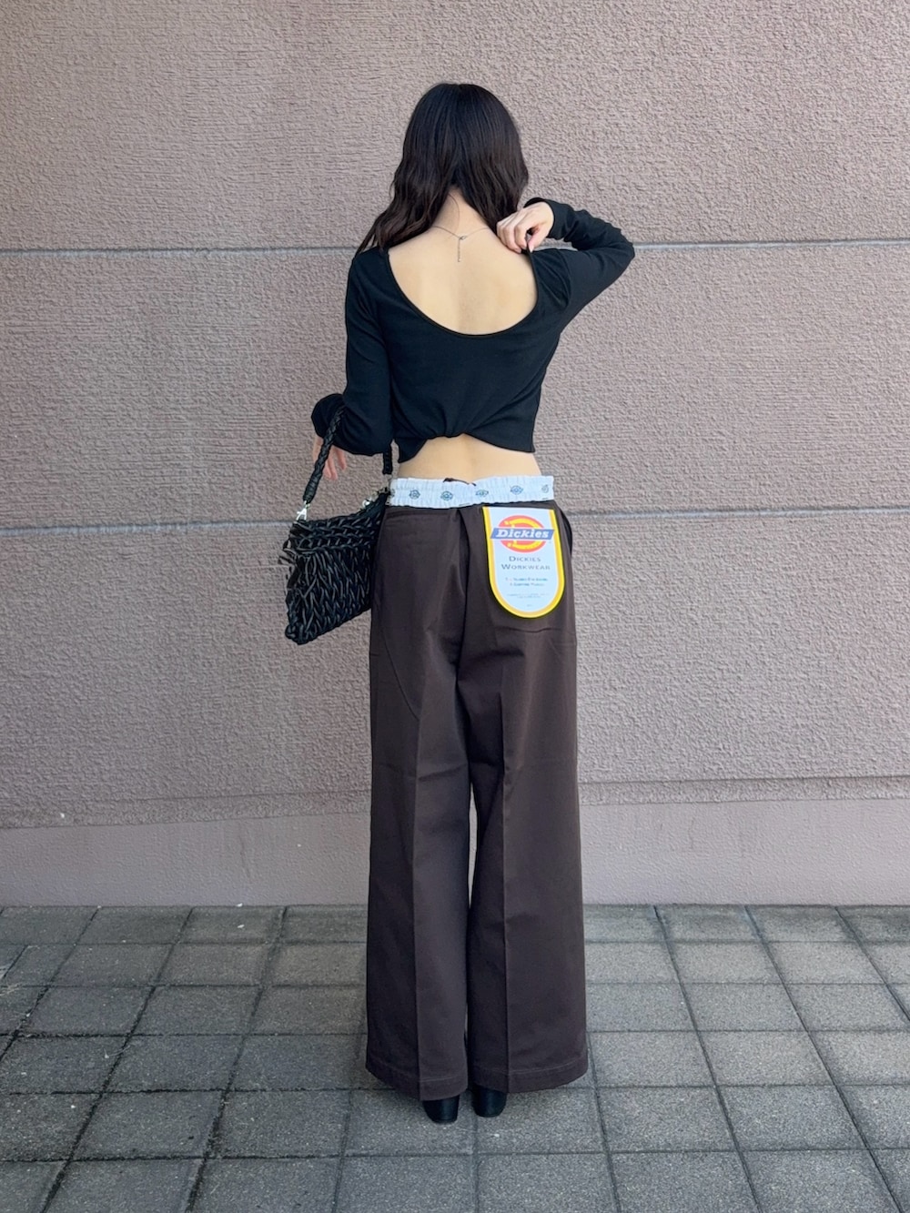 ブラック系のハンドバッグ、ブラック系のTシャツ/カットソー、ブラウン系のその他パンツを着用したレディースの秋コーディネートの3枚目の写真