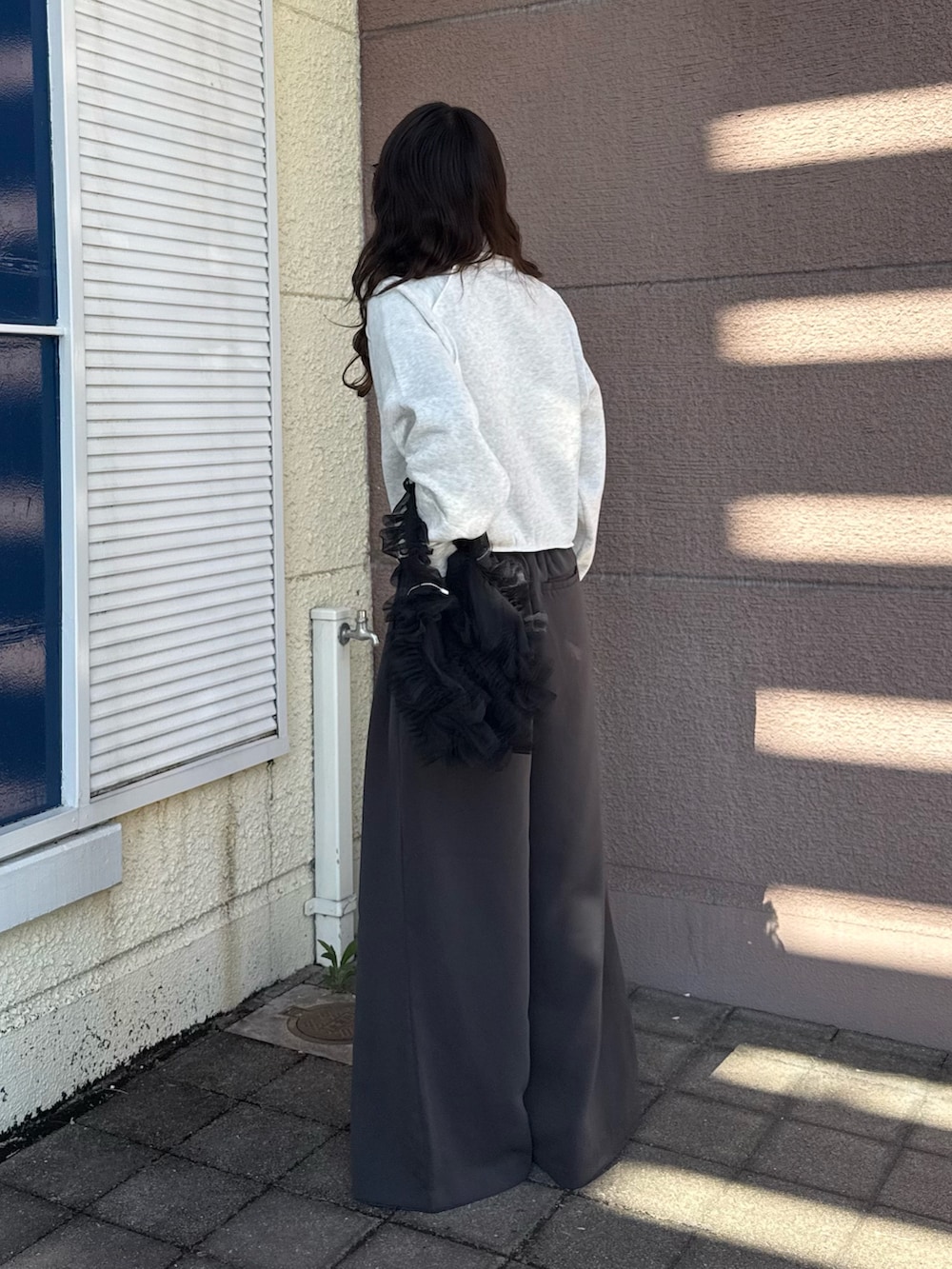 グレー系のその他パンツ、ブラック系のハンドバッグを着用したレディースの秋コーディネートの2枚目の写真