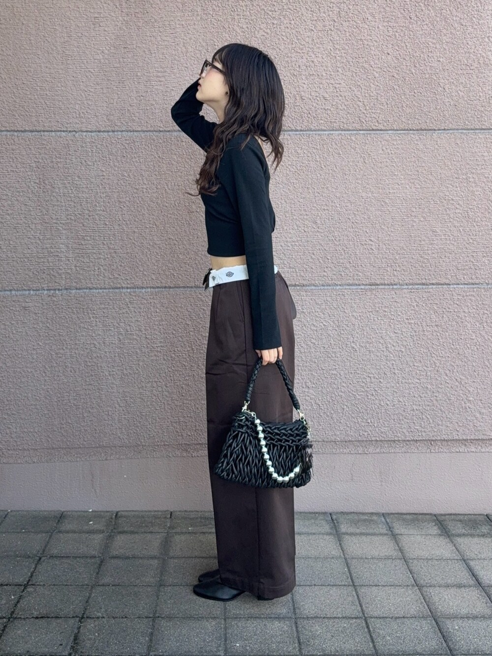 ブラック系のハンドバッグ、ブラック系のTシャツ/カットソー、ブラウン系のその他パンツを着用したレディースの秋コーディネートの2枚目の写真