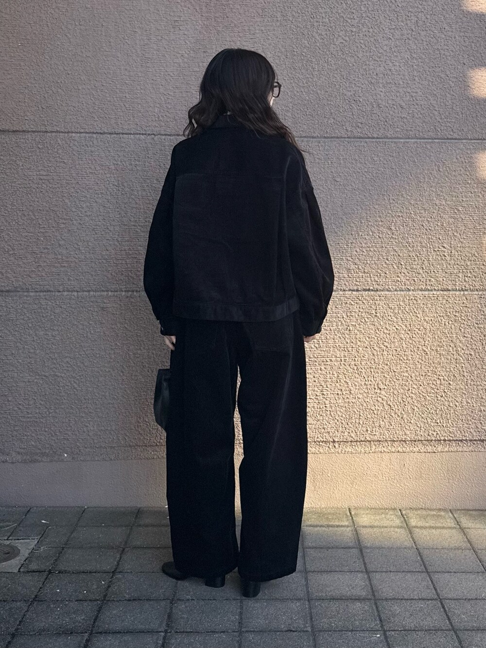 ブラック系のその他アウター、ブラック系のその他パンツ、ブラック系のショルダーバッグを着用したレディースの秋コーディネートの3枚目の写真