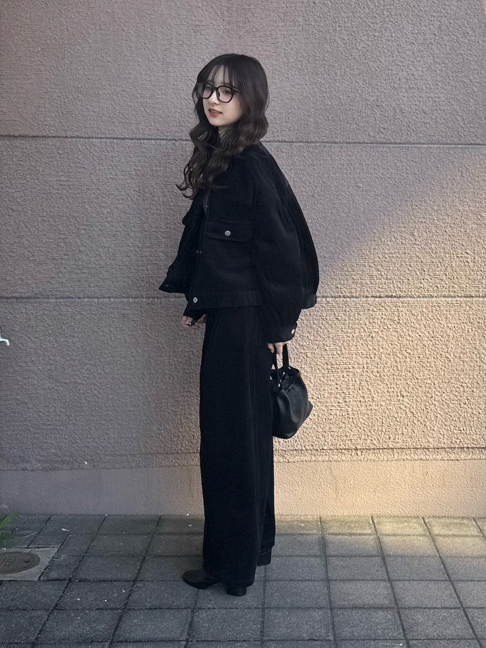 ブラック系のその他アウター、ブラック系のその他パンツ、ブラック系のショルダーバッグを着用したレディースの秋コーディネートの2枚目の写真