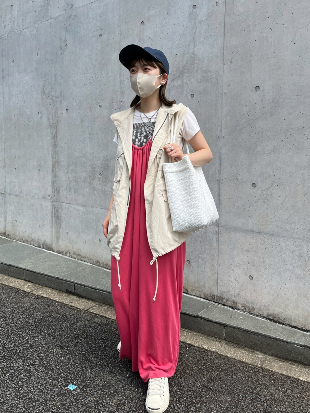ピンク系のワンピース、ホワイト系のダウンベスト、ホワイト系のTシャツ/カットソーを着用したレディースの夏コーディネートの2枚目の写真