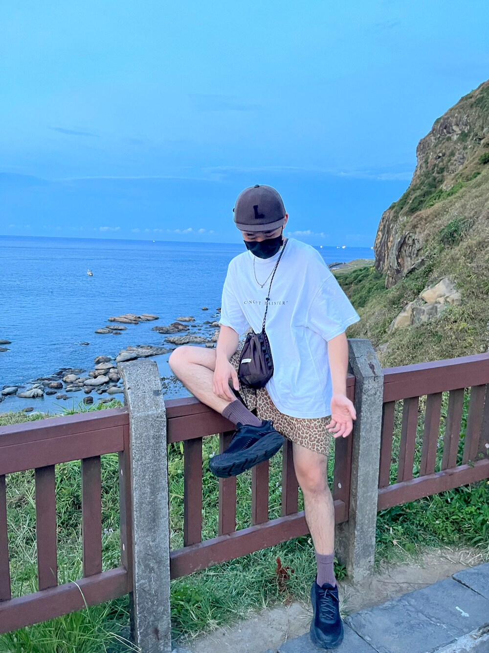 ホワイト系のTシャツ/カットソー、イエロー系のカーゴパンツ、ブラック系のスニーカーを着用したメンズの秋コーディネートの2枚目の写真