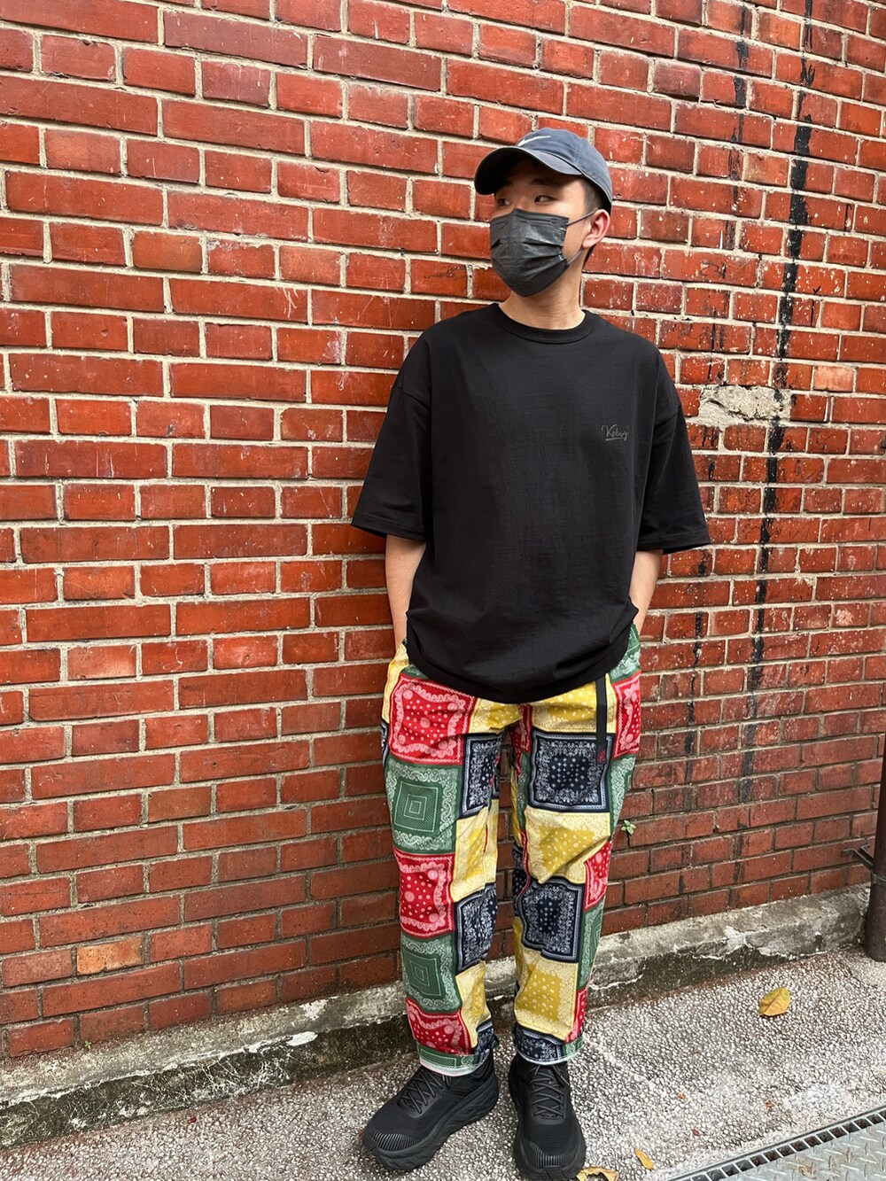 ブラック系のTシャツ/カットソー、その他のチノパンツ、ブラック系のスニーカーを着用したメンズの春コーディネートの2枚目の写真