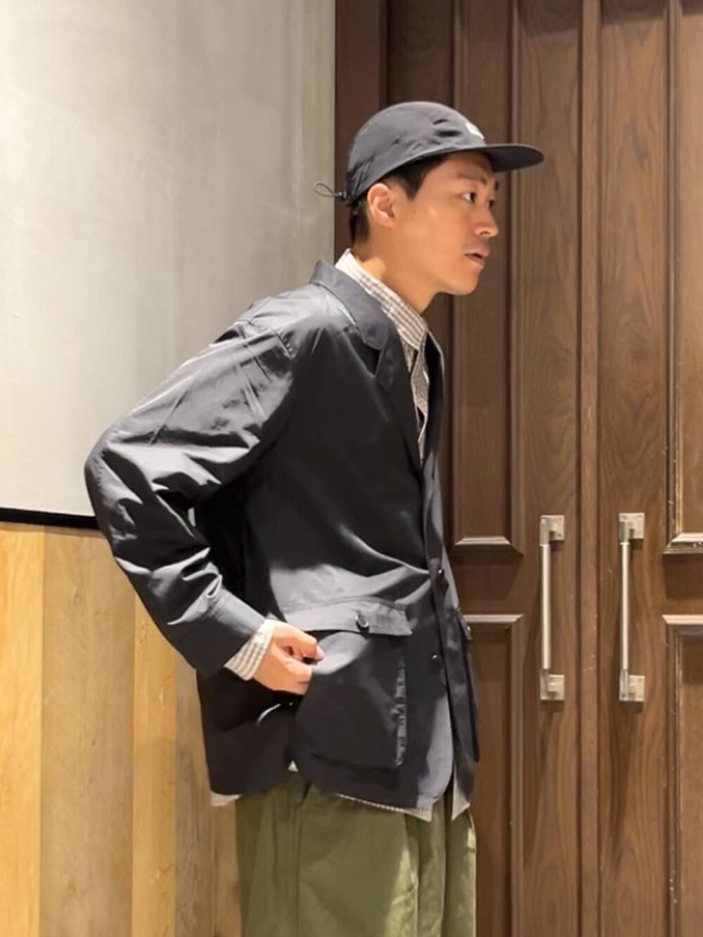 グリーン系のカーゴパンツ、ブラウン系のシャツ/ブラウス、ブラック系のカバーオールを着用したメンズの夏コーディネートの6枚目の写真