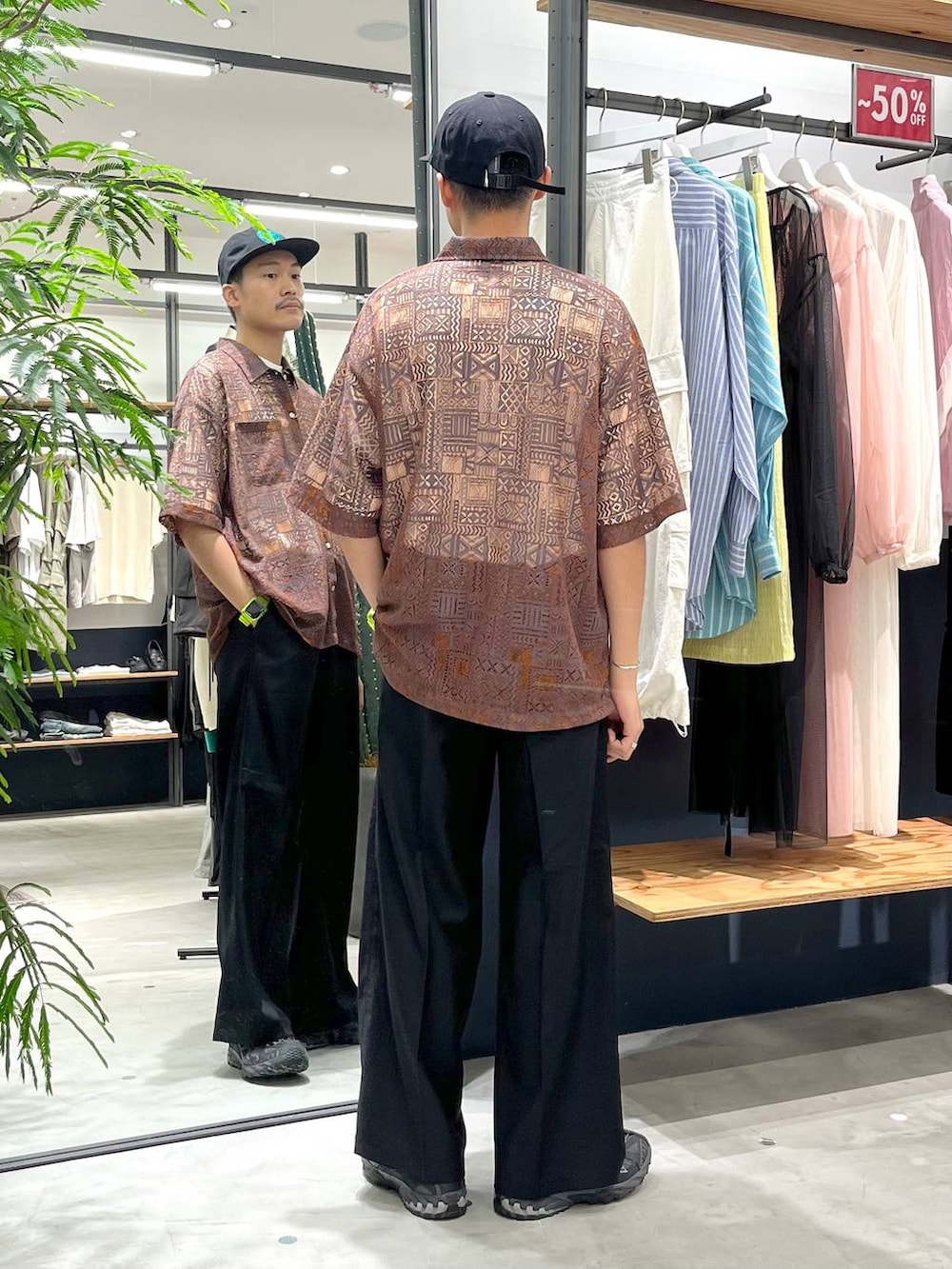 オレンジ系のシャツ/ブラウス、ホワイト系のTシャツ/カットソー、ブラック系のスラックスを着用したメンズの夏コーディネートの3枚目の写真