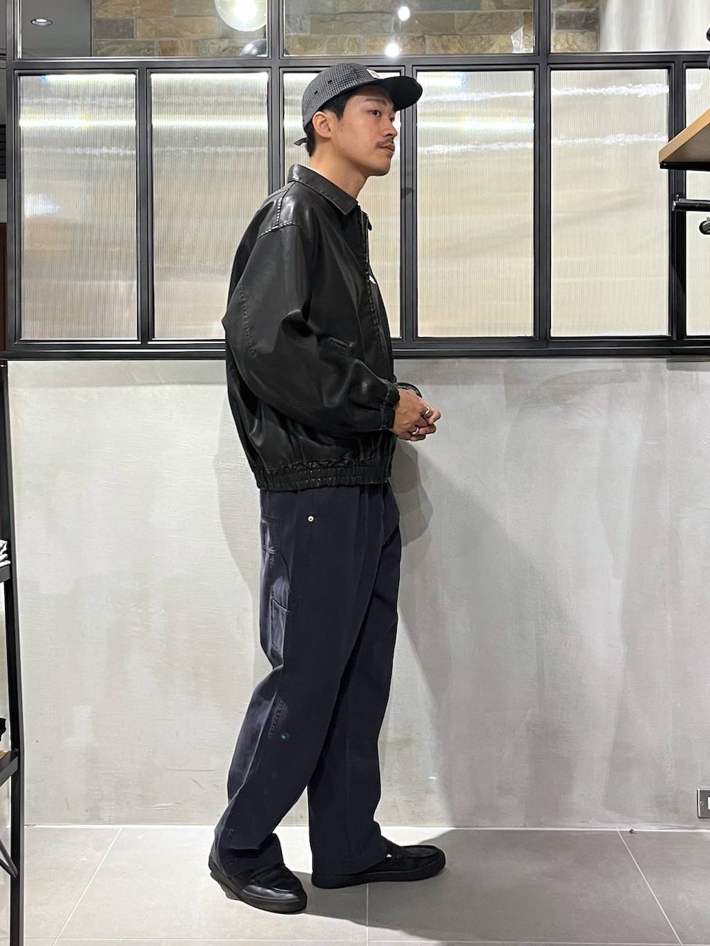 ブラック系のブルゾン、ブルー系のデニムパンツ、ピンク系のシャツ/ブラウスを着用したメンズの秋コーディネートの2枚目の写真