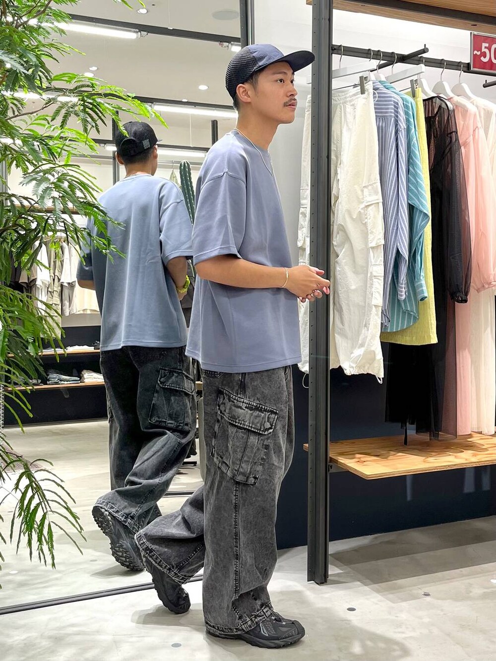 グレー系のデニムパンツ、ブルー系のTシャツ/カットソー、ホワイト系のネックレスを着用したメンズの夏コーディネートの2枚目の写真