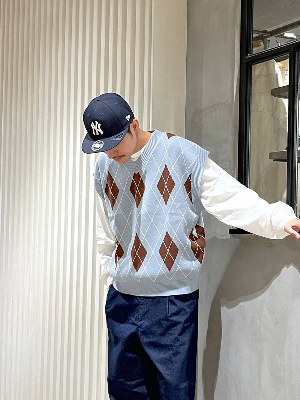ブラック系のドレスシューズ、ブルー系のベスト、ホワイト系のTシャツ/カットソーを着用したメンズの春コーディネートの4枚目の写真
