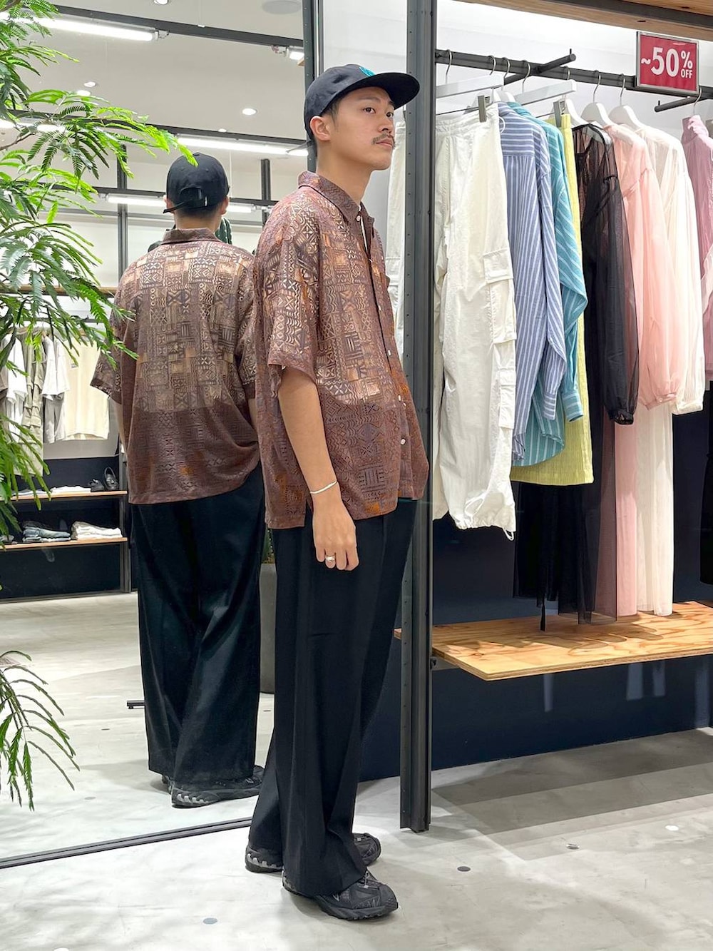 オレンジ系のシャツ/ブラウス、ホワイト系のTシャツ/カットソー、ブラック系のスラックスを着用したメンズの夏コーディネートの2枚目の写真