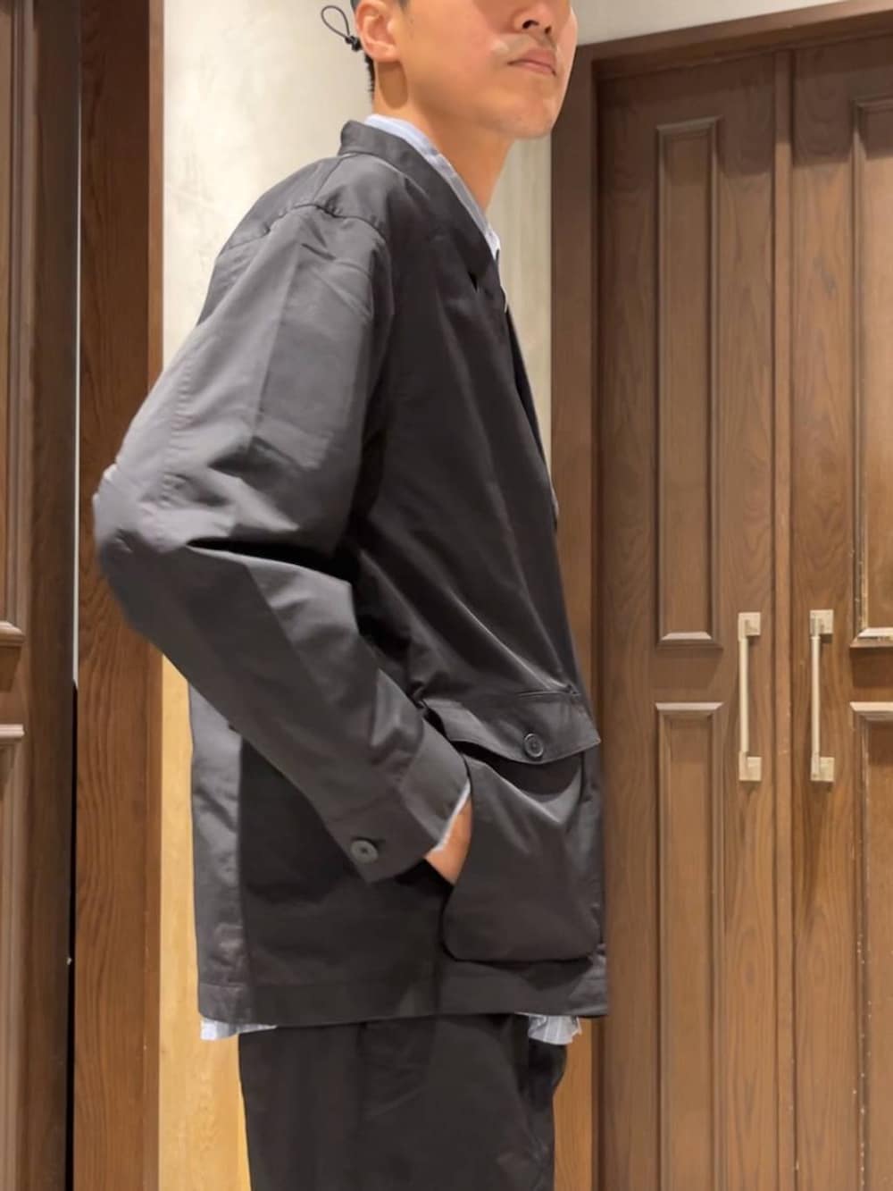 ブルー系のシャツ/ブラウス、ブラック系のスラックス、ブラック系のカバーオールを着用したメンズの夏コーディネートの4枚目の写真