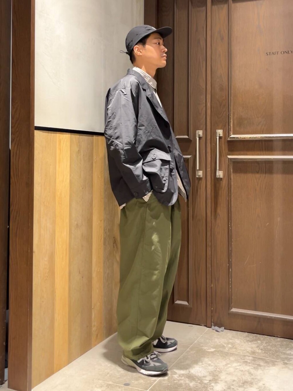 グリーン系のカーゴパンツ、ブラウン系のシャツ/ブラウス、ブラック系のカバーオールを着用したメンズの夏コーディネートの4枚目の写真