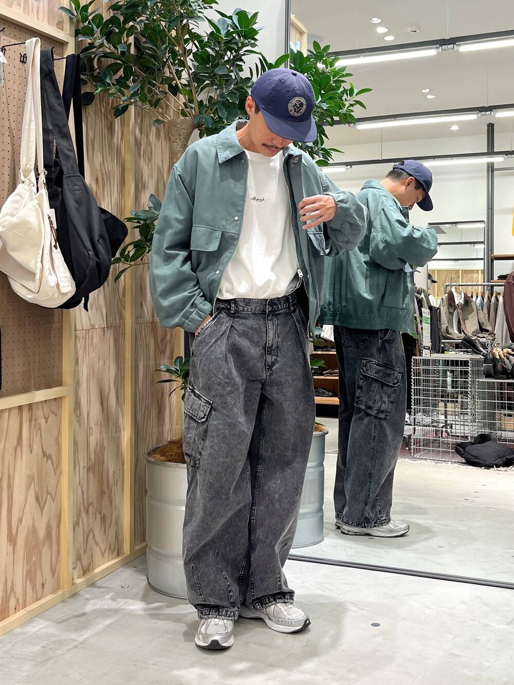 グレー系のデニムパンツ、ホワイト系のTシャツ/カットソー、グリーン系のブルゾンを着用したメンズの秋コーディネートの3枚目の写真