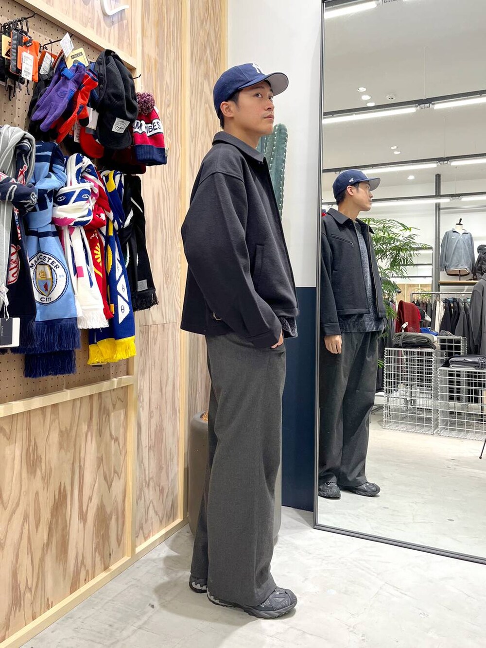 ブラック系のブルゾン、グレー系のスラックス、ホワイト系のTシャツ/カットソーを着用したメンズの秋コーディネートの2枚目の写真