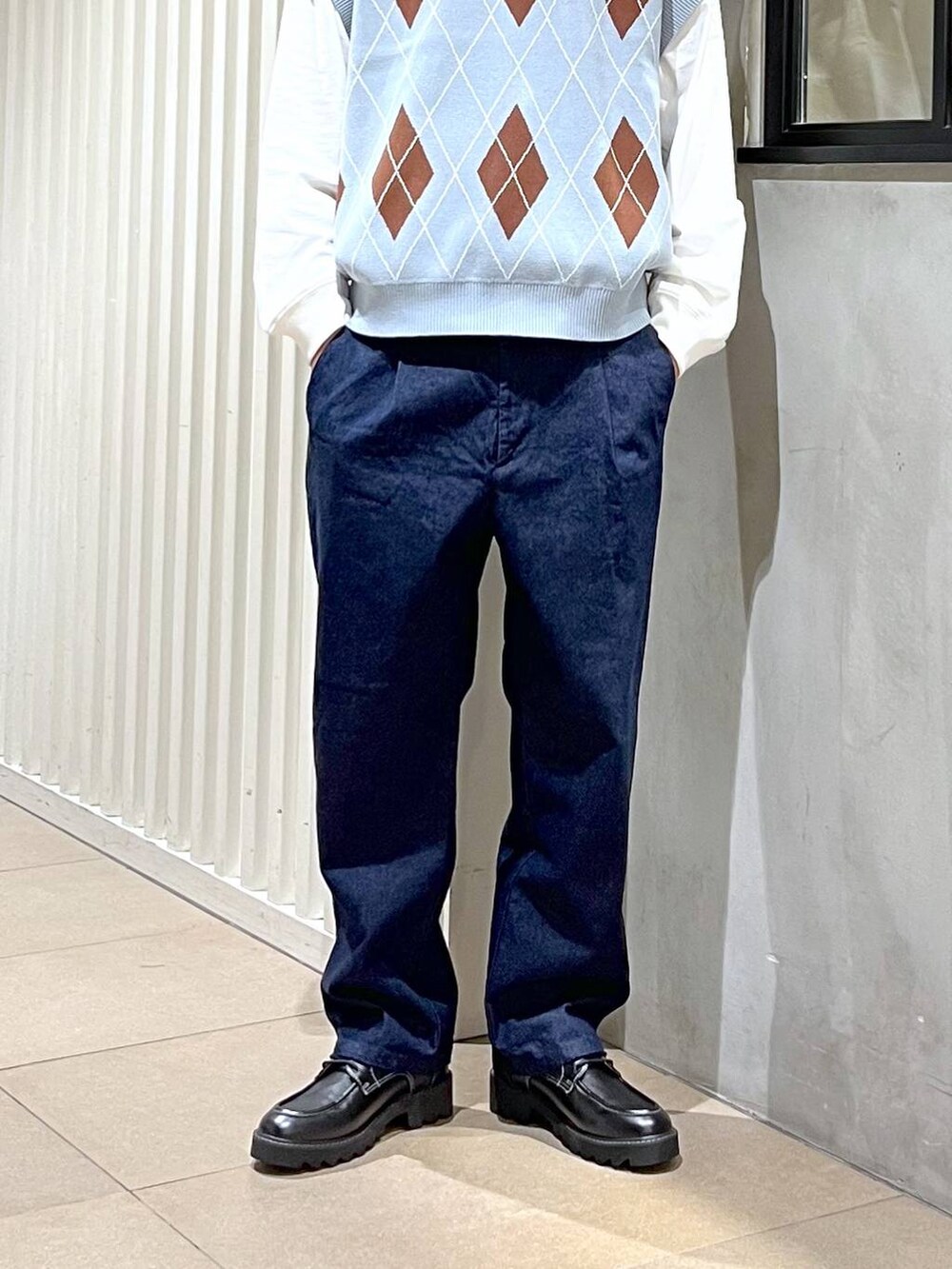 ブラック系のドレスシューズ、ブルー系のベスト、ホワイト系のTシャツ/カットソーを着用したメンズの春コーディネートの3枚目の写真
