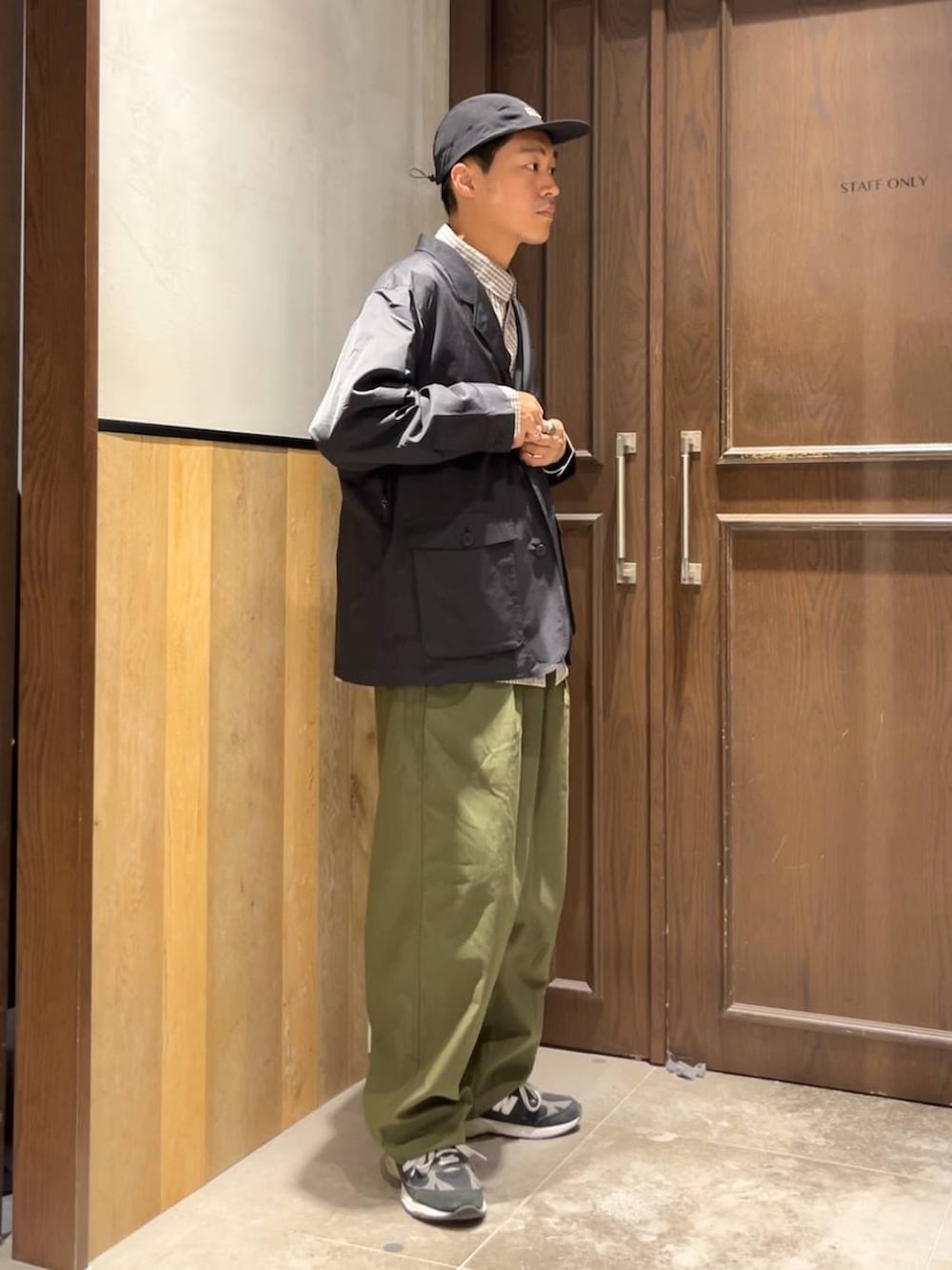 グリーン系のカーゴパンツ、ブラウン系のシャツ/ブラウス、ブラック系のカバーオールを着用したメンズの夏コーディネートの2枚目の写真