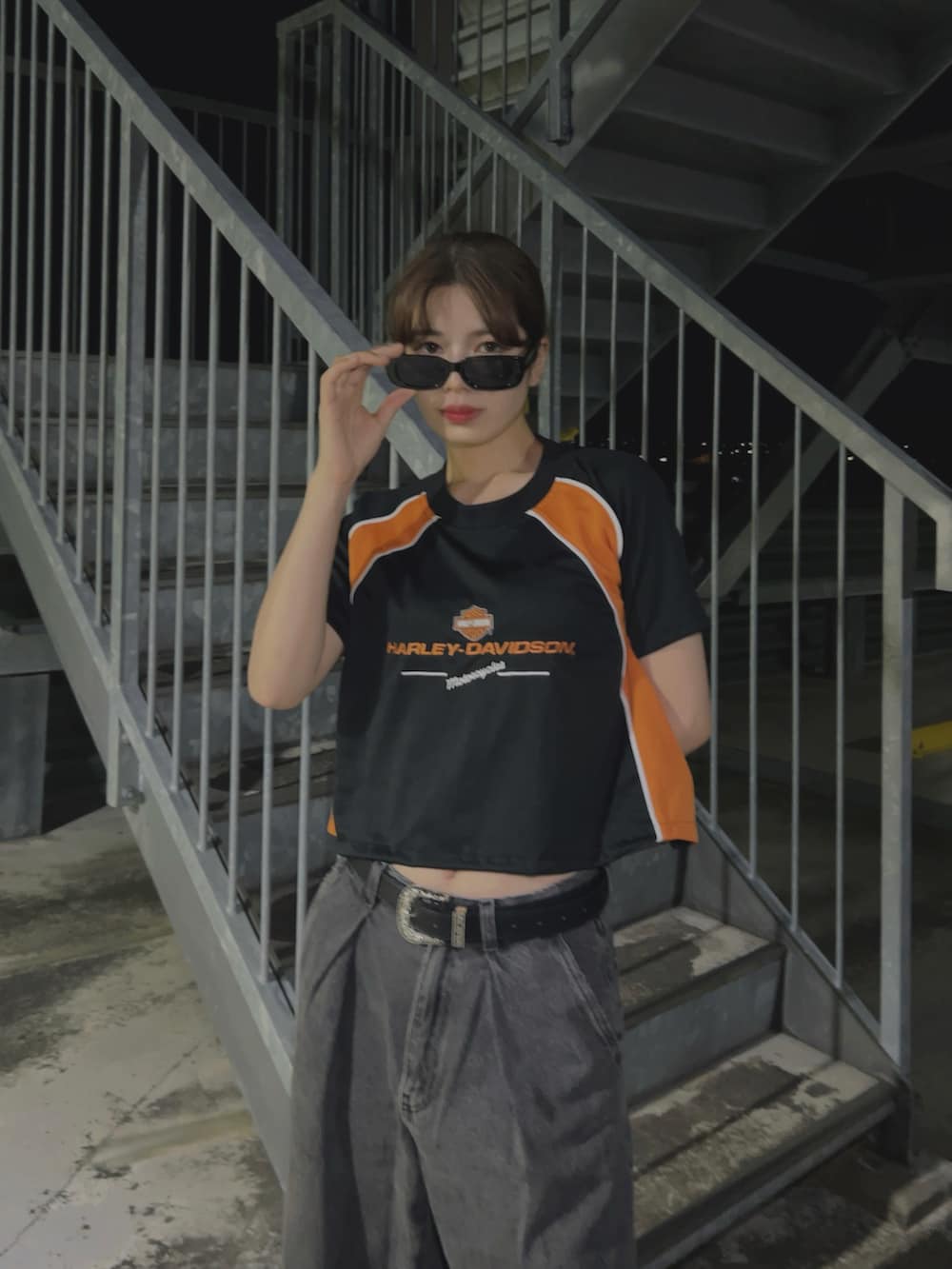 ブラック系のTシャツ/カットソー、ブラック系のスニーカー、グレー系のデニムパンツを着用したレディースの夏コーディネートの2枚目の写真