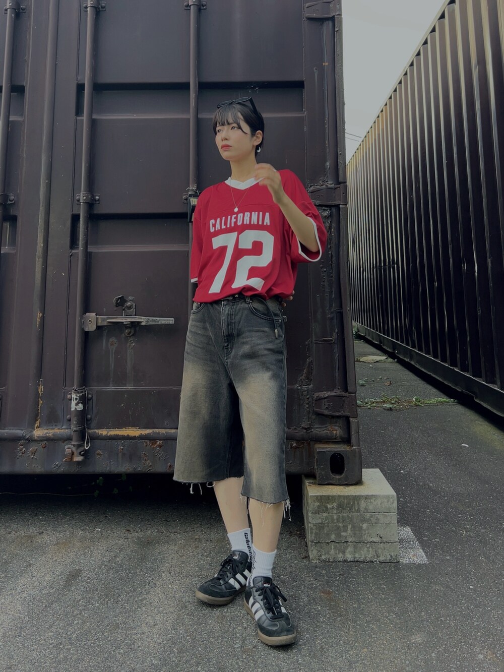 ブラック系のスニーカー、レッド系のTシャツ/カットソーを着用したレディースの夏コーディネートの2枚目の写真