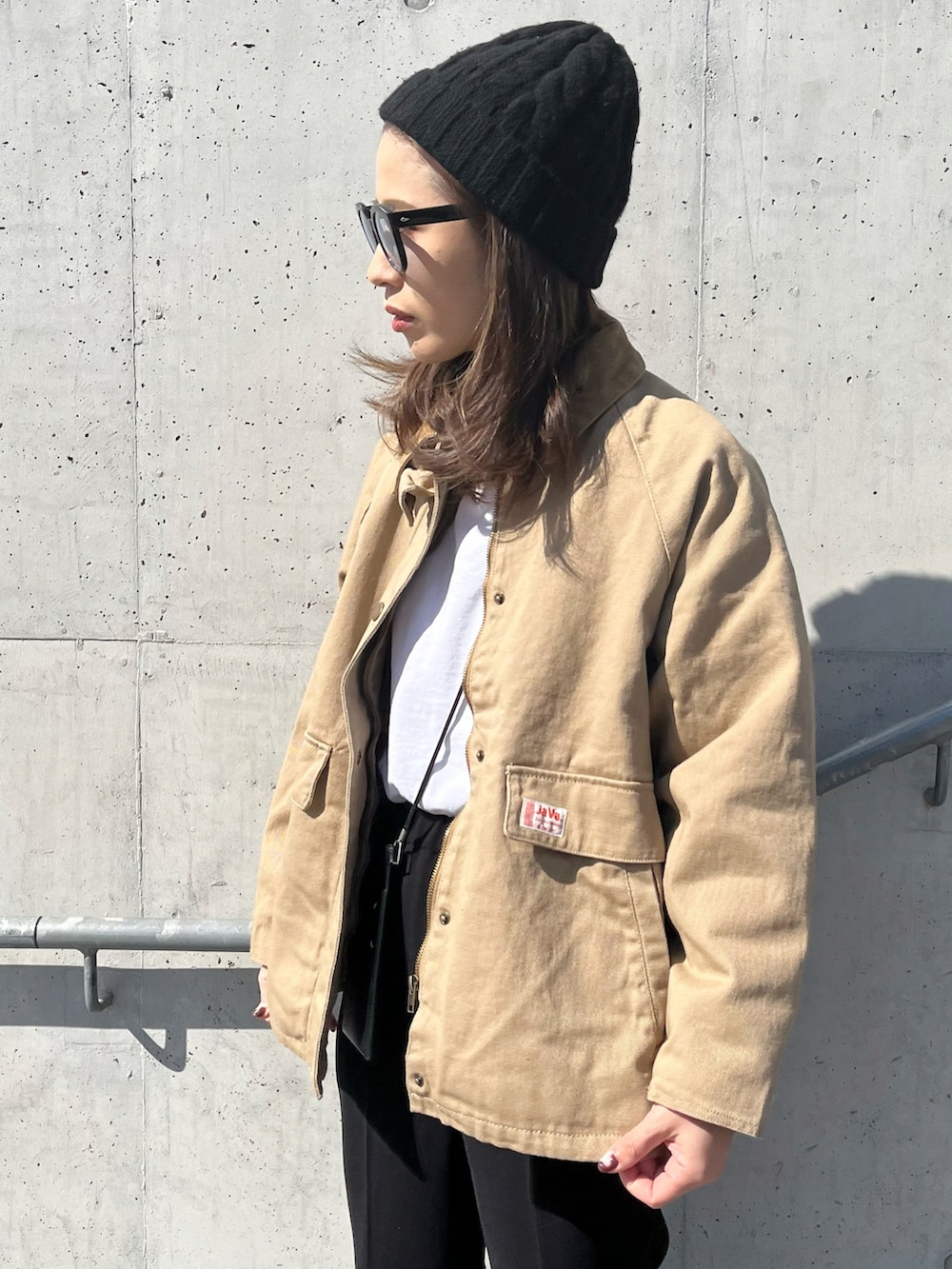 ベージュ系のブルゾン、ブラック系のその他パンツ、ブラック系のサングラスを着用したレディースの春コーディネートの2枚目の写真