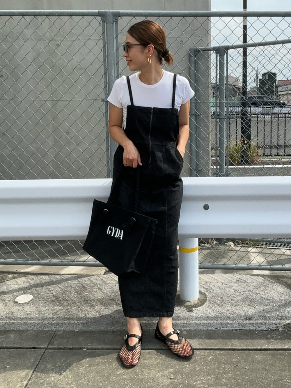 ブラック系のトートバッグ、ブラック系のワンピースを着用したレディースの夏コーディネートの3枚目の写真