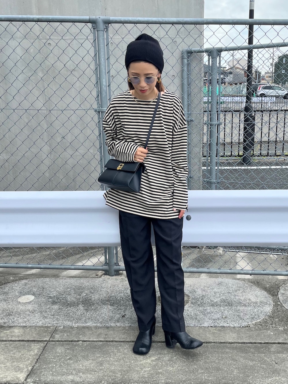 ベージュ系のTシャツ/カットソー、ブラック系のバッグ、ブラック系のブーツを着用したレディースの秋コーディネートの3枚目の写真