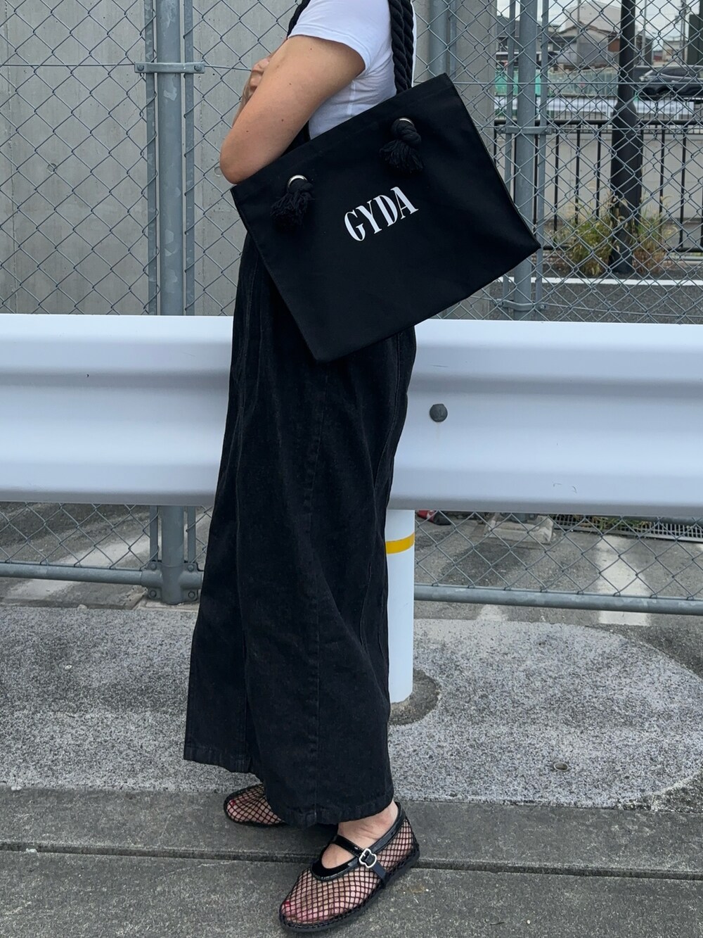 ブラック系のトートバッグ、ブラック系のワンピースを着用したレディースの夏コーディネートの2枚目の写真