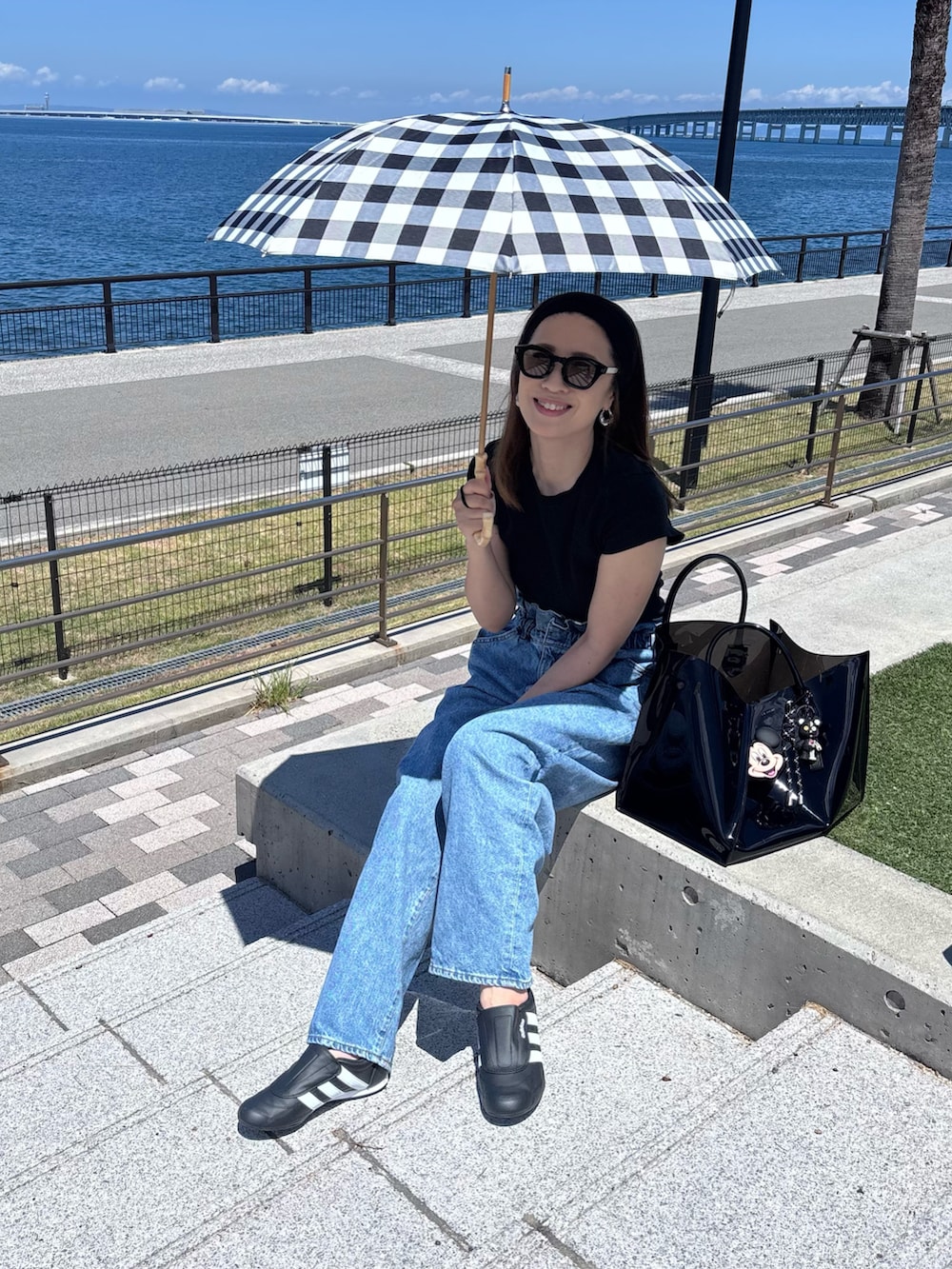 ブルー系のデニムパンツ、ブラック系のヘアバンドを着用したレディースの夏コーディネートの2枚目の写真