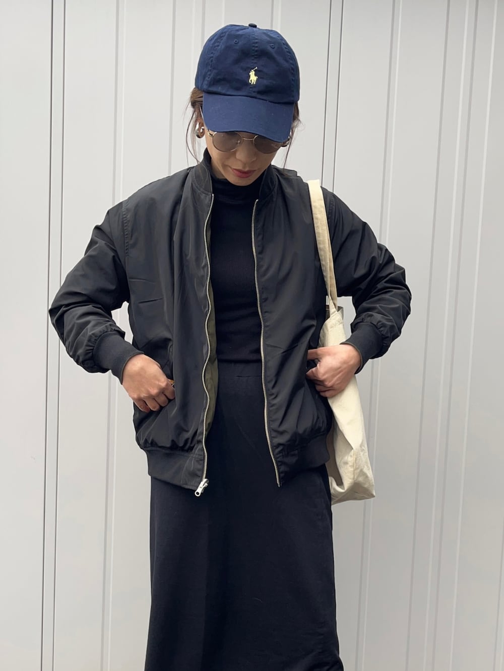 グリーン系のMA-1、ブラック系のスニーカー、グレー系のサングラスを着用したレディースの春コーディネートの4枚目の写真