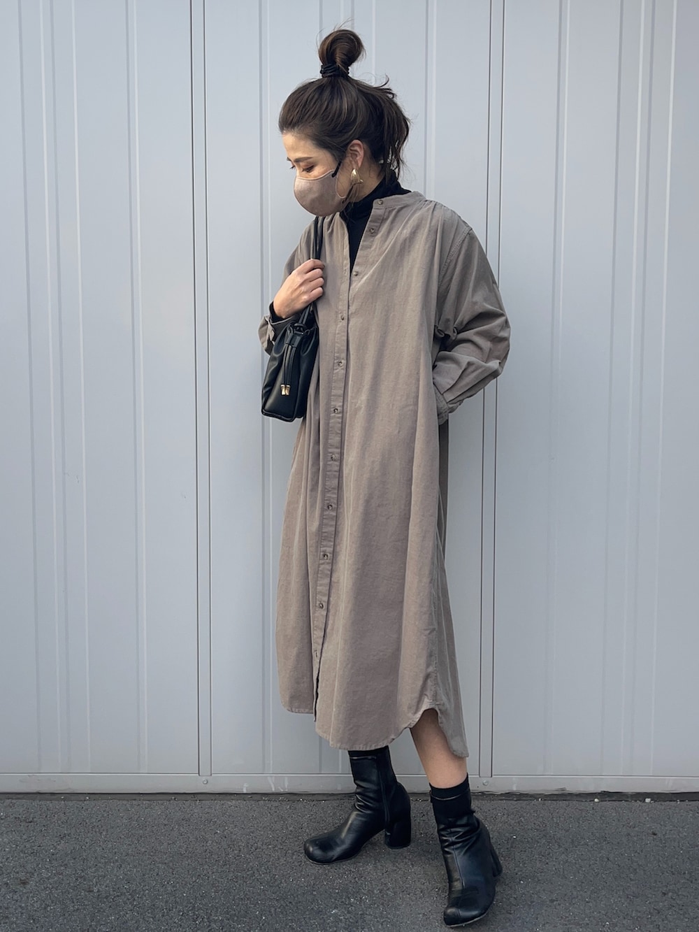 ベージュ系のワンピース、ブラック系のショルダーバッグを着用したレディースの冬コーディネートの2枚目の写真